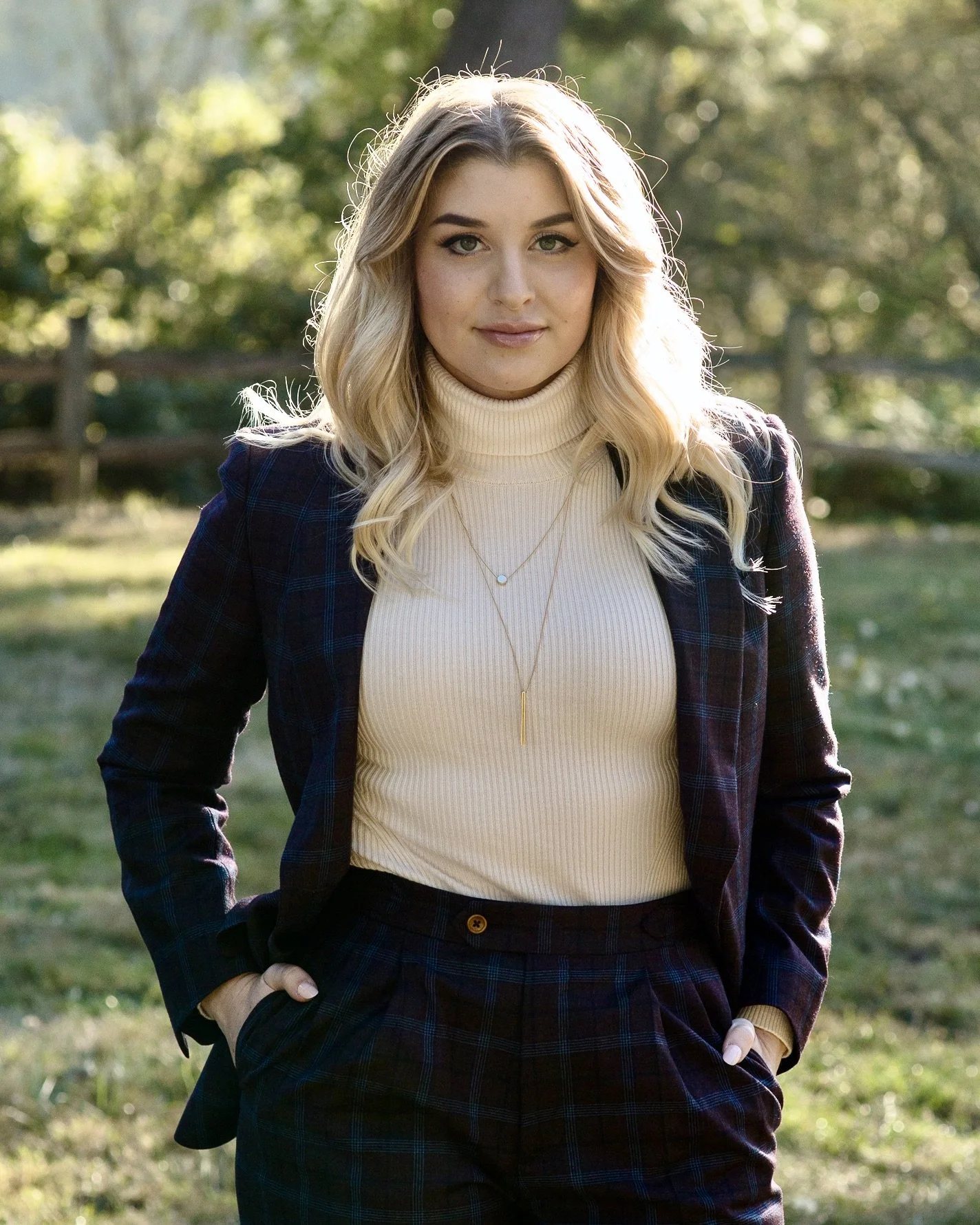 Baili directly into the camera, with bright eyes and soft blonde waves falling past her shoulders