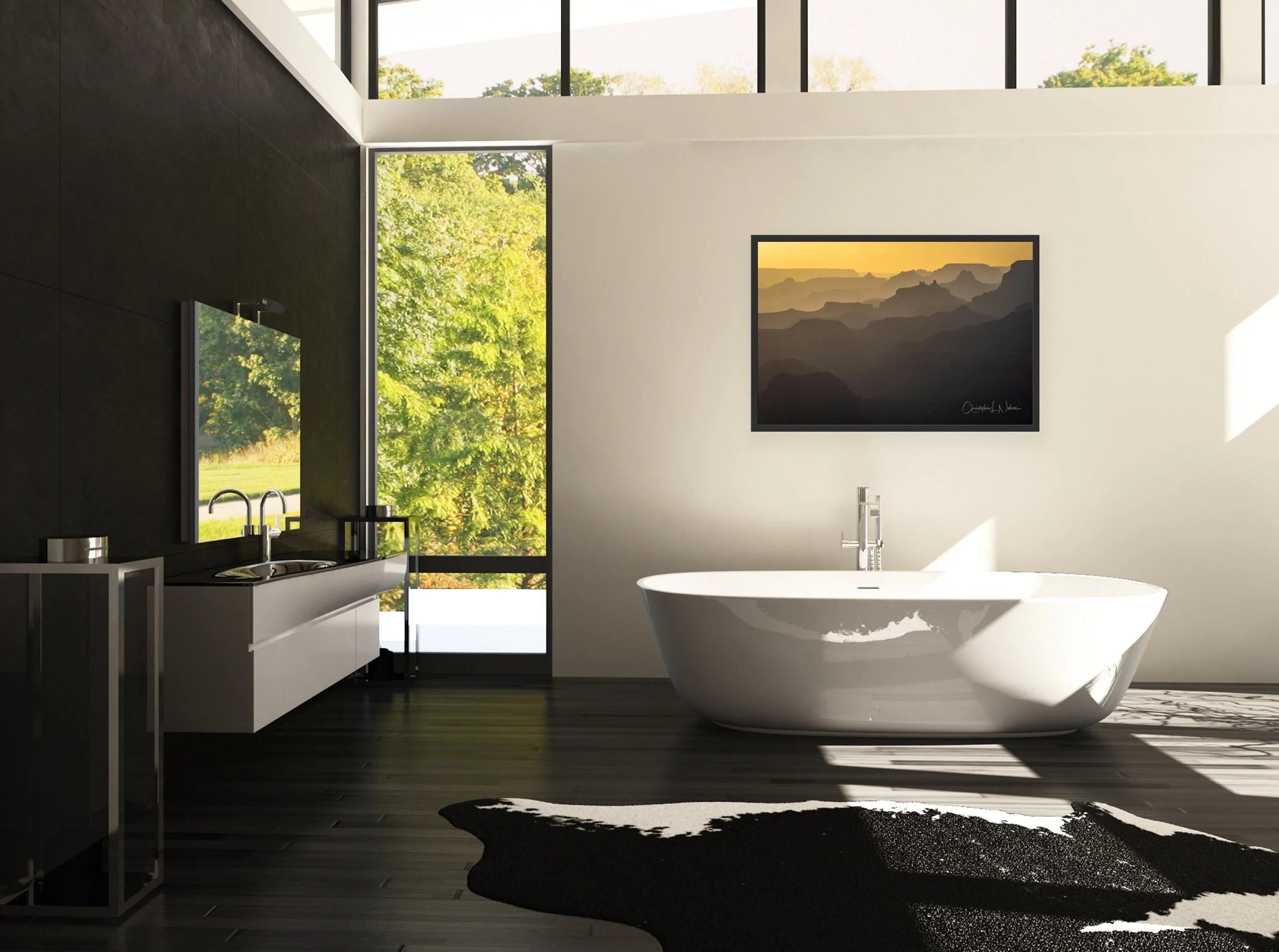 Modern bathroom with a white bathtub, a black accent wall with a mirror and sink, large windows showing green trees outside, a black and white cowhide rug on dark wood flooring, and a framed mountain landscape picture on the wall.