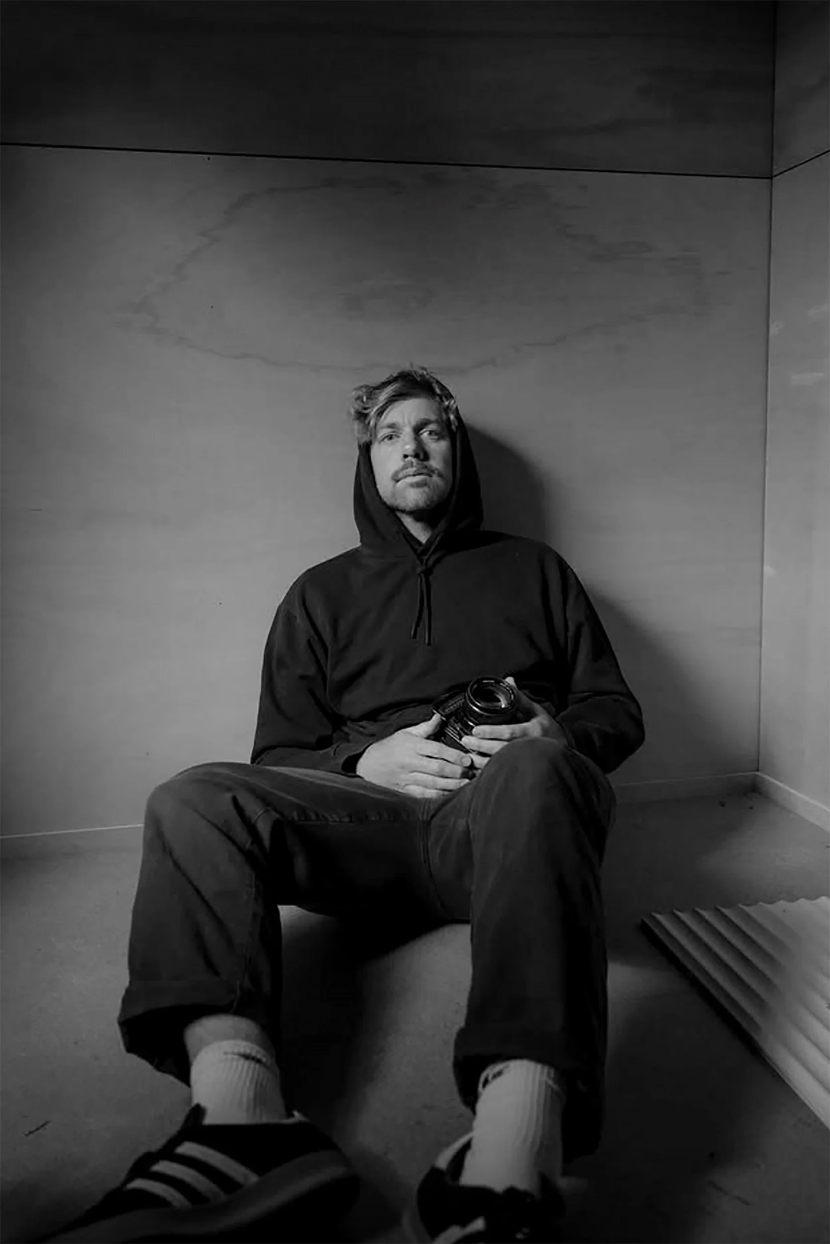 A man with glasses, dark hair, and a beard gazing thoughtfully.