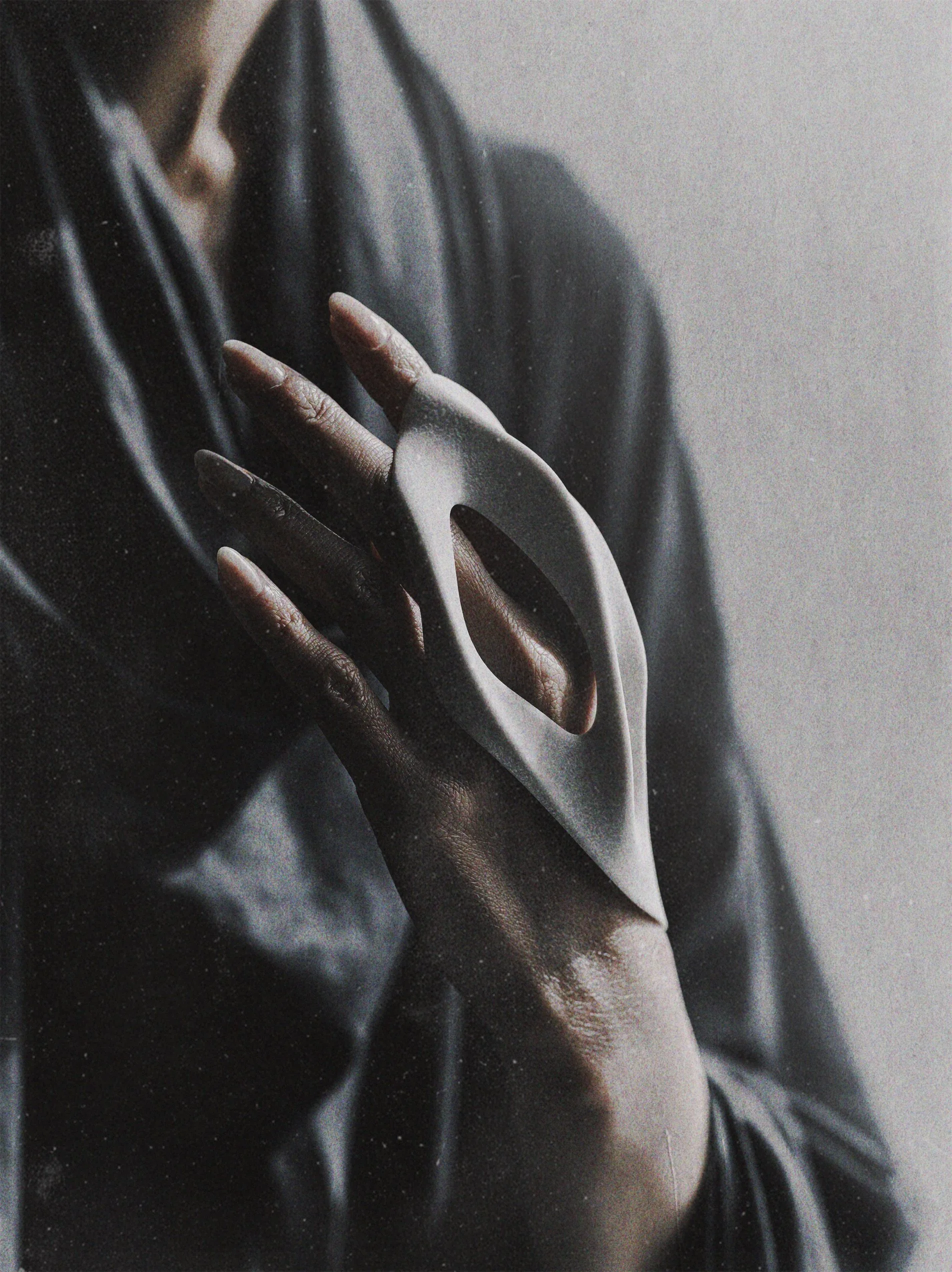 Bone-grey sculptural wrist cuff with porous openings worn as part of the Body Fragments collection.