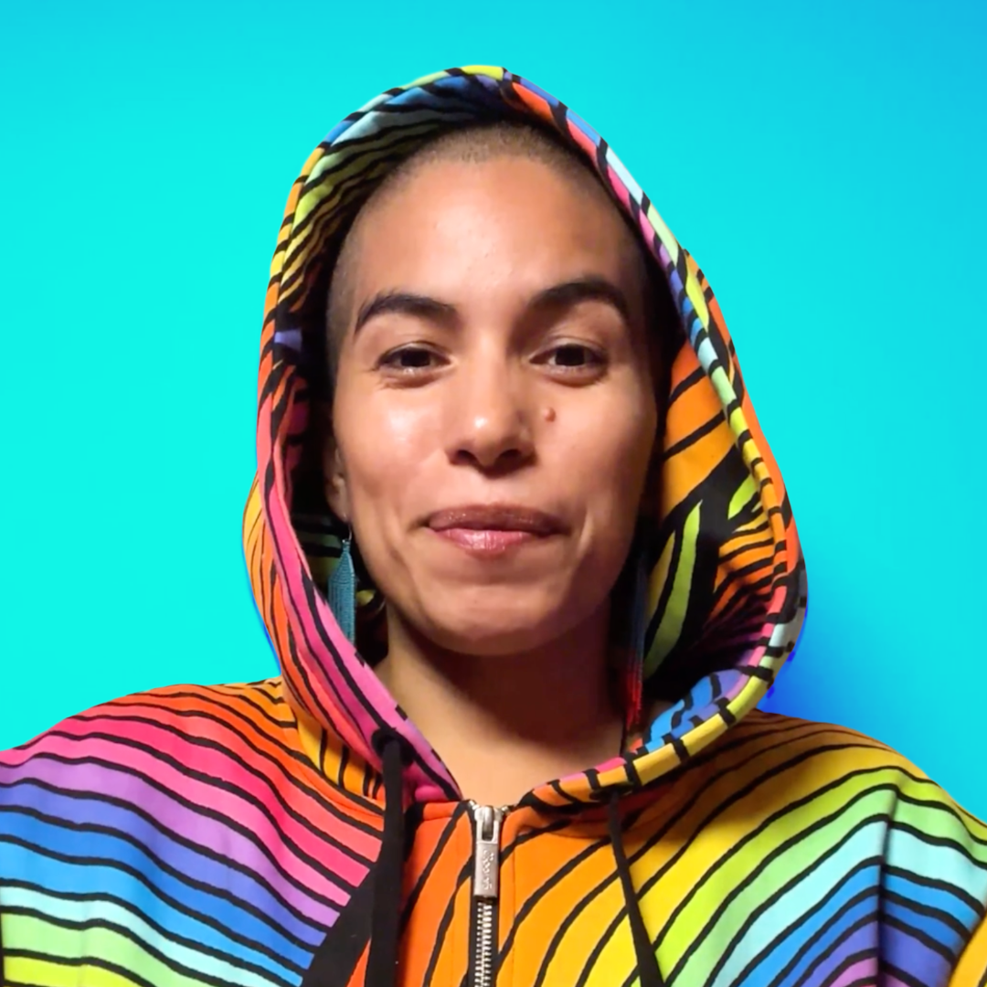 A non-binary being wearing a multicolored rainbow-striped hoodie with a bright blue background.