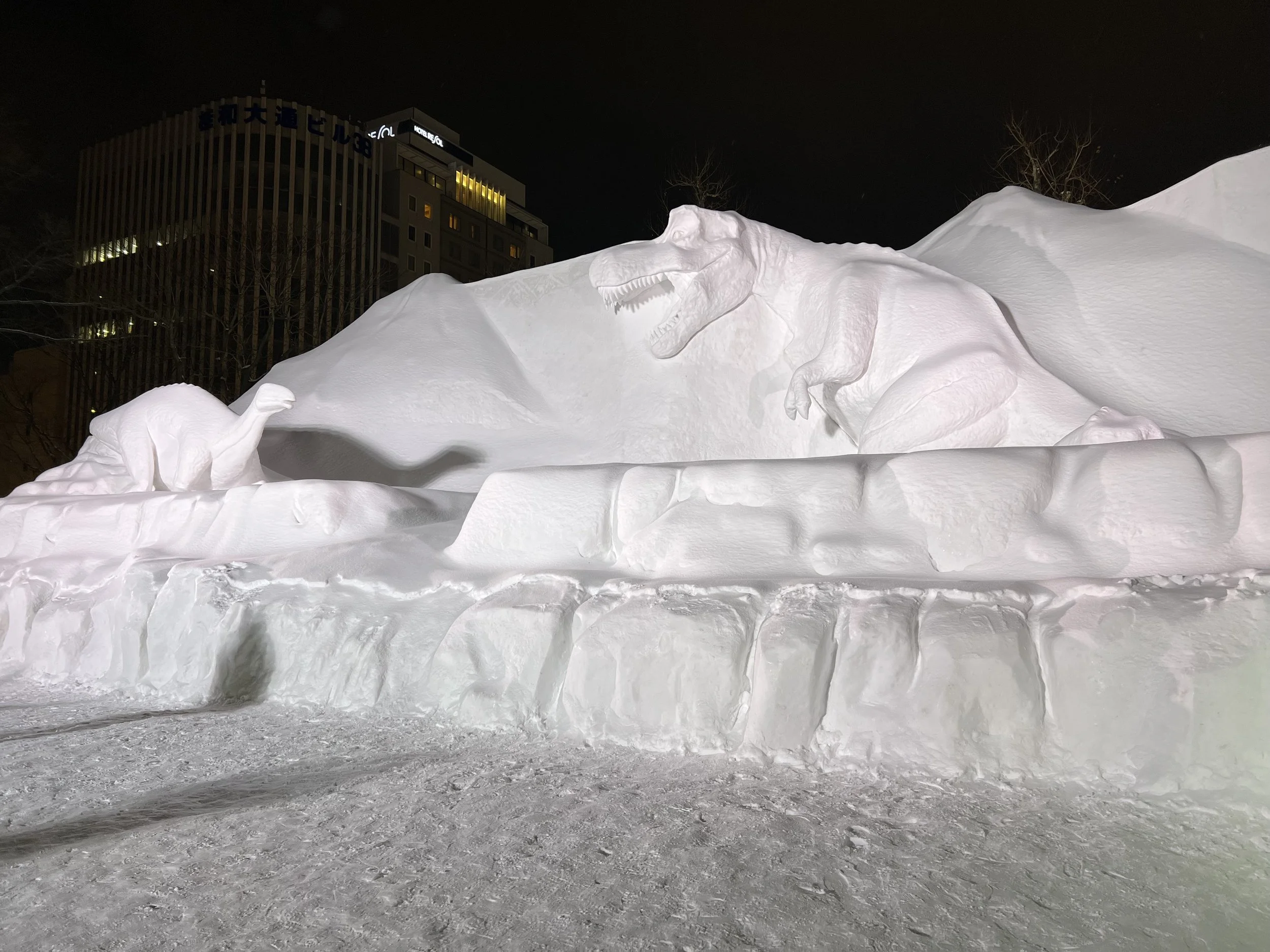 Dinosaures snow sculptures at Sapporo Snow Festival at night in 2023