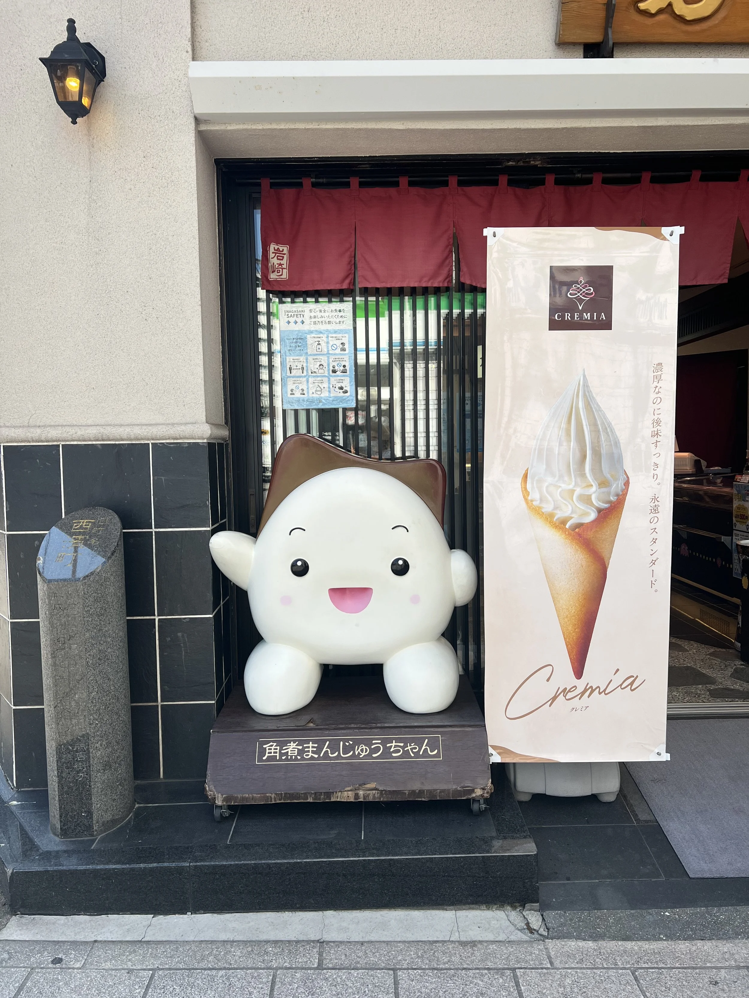 Cute kakuni manju mascot in front of a shop in Nagasaki