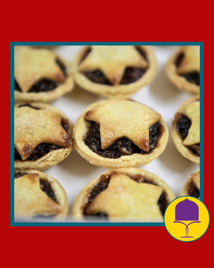 Fruit mince pies with star tops on a white plate with Christmas decorations