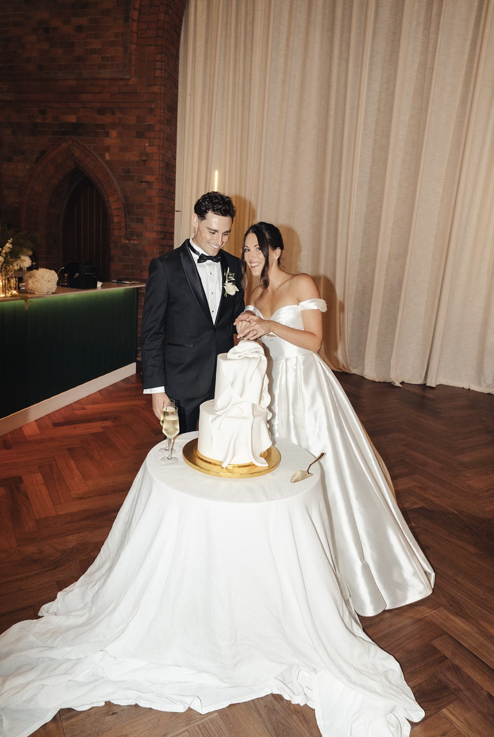 Claudia and Zac cutting their fondant wedding cake at Ravella, Newcastle