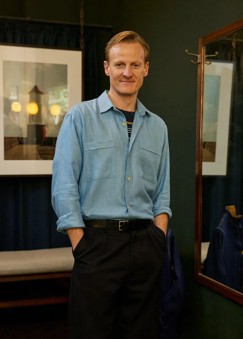 George of Original Fibres wearing a blue linen shirt standing in his Bloomsbury menswear store