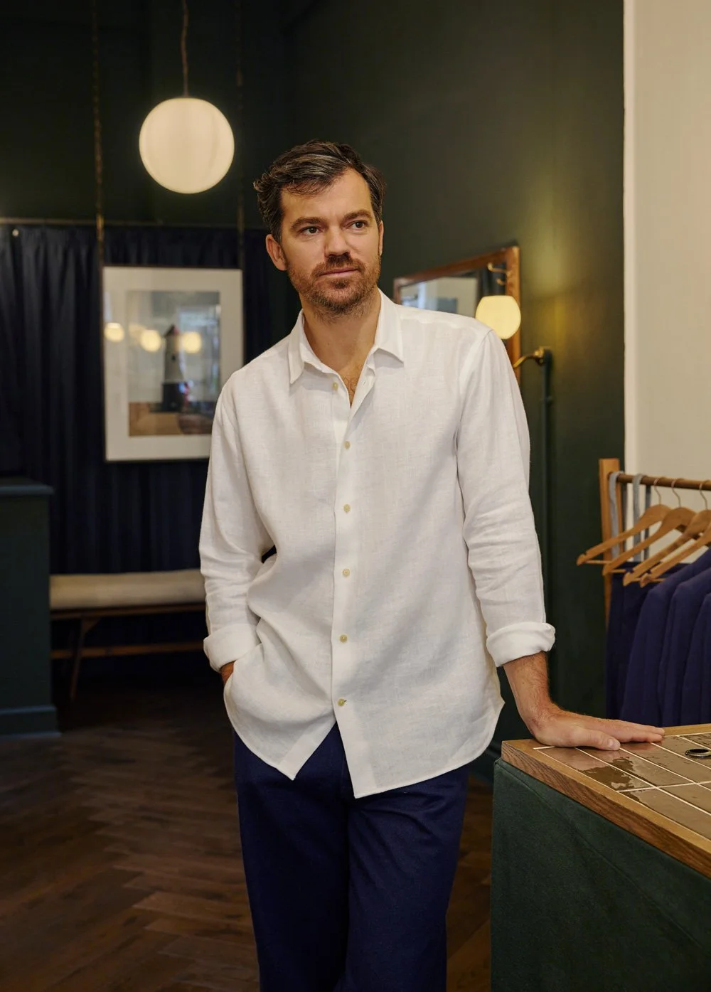 Callum of Original Fibres wearing a white linen shirt standing in their Bloomsbury menswear store