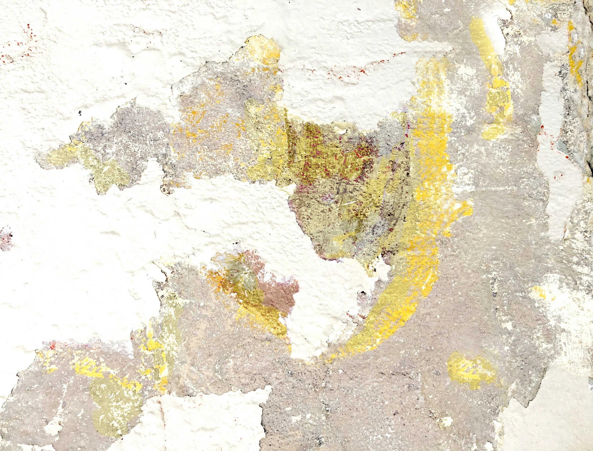 Close-up of peeling paint on a textured wall with patches of yellow, beige, and gray paint.