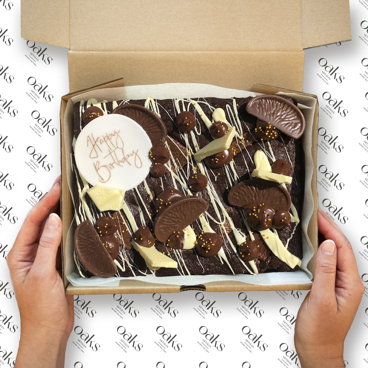 A customisable Celebration Chocolate Brownie, topped with an assortment of sweet treats, a handmade edible text topper. The brownie is decorated and ideal for any occasion or celebration.