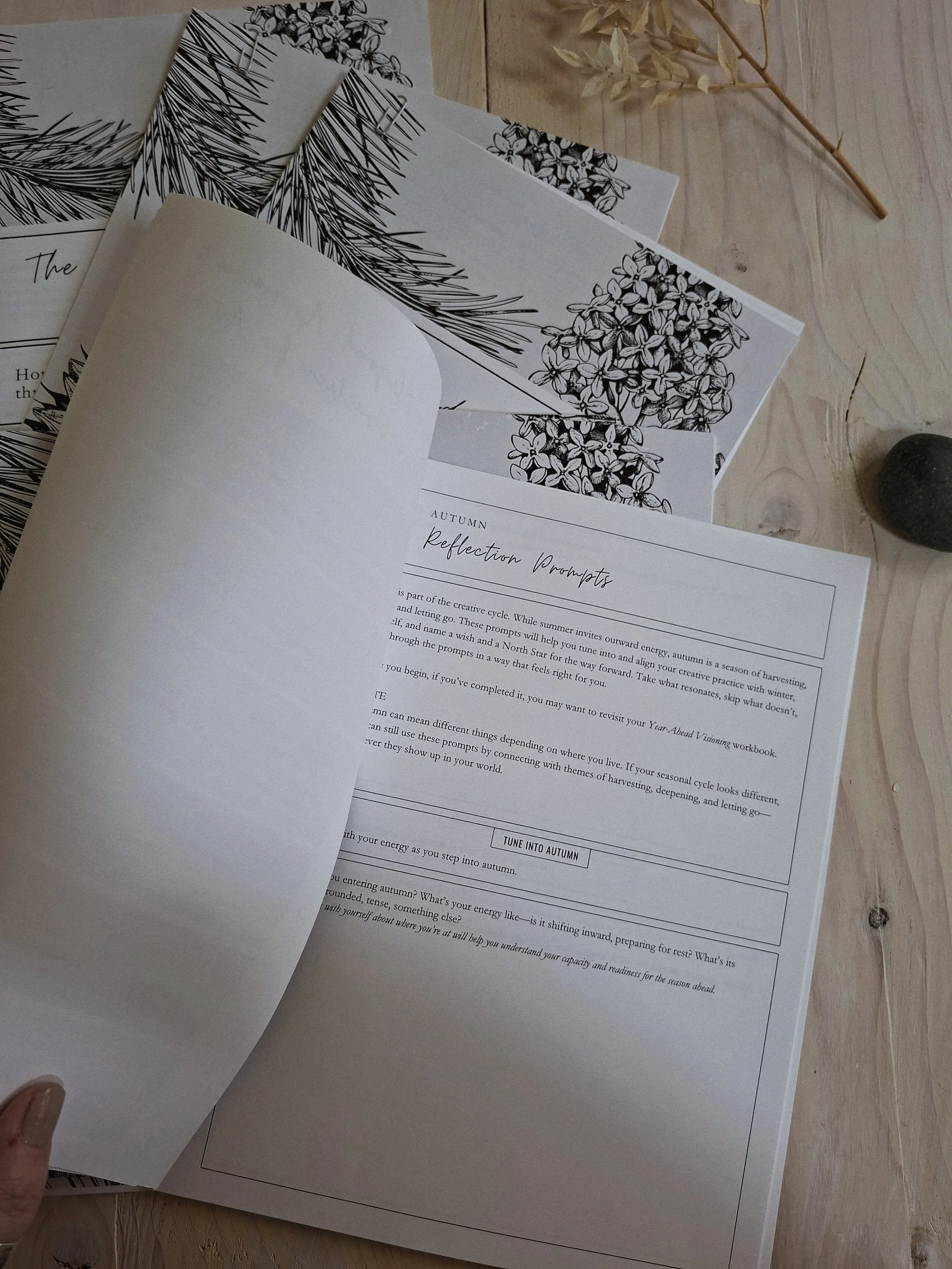 The Seasonal Creator Almanac open to a workbook page of reflective questions.