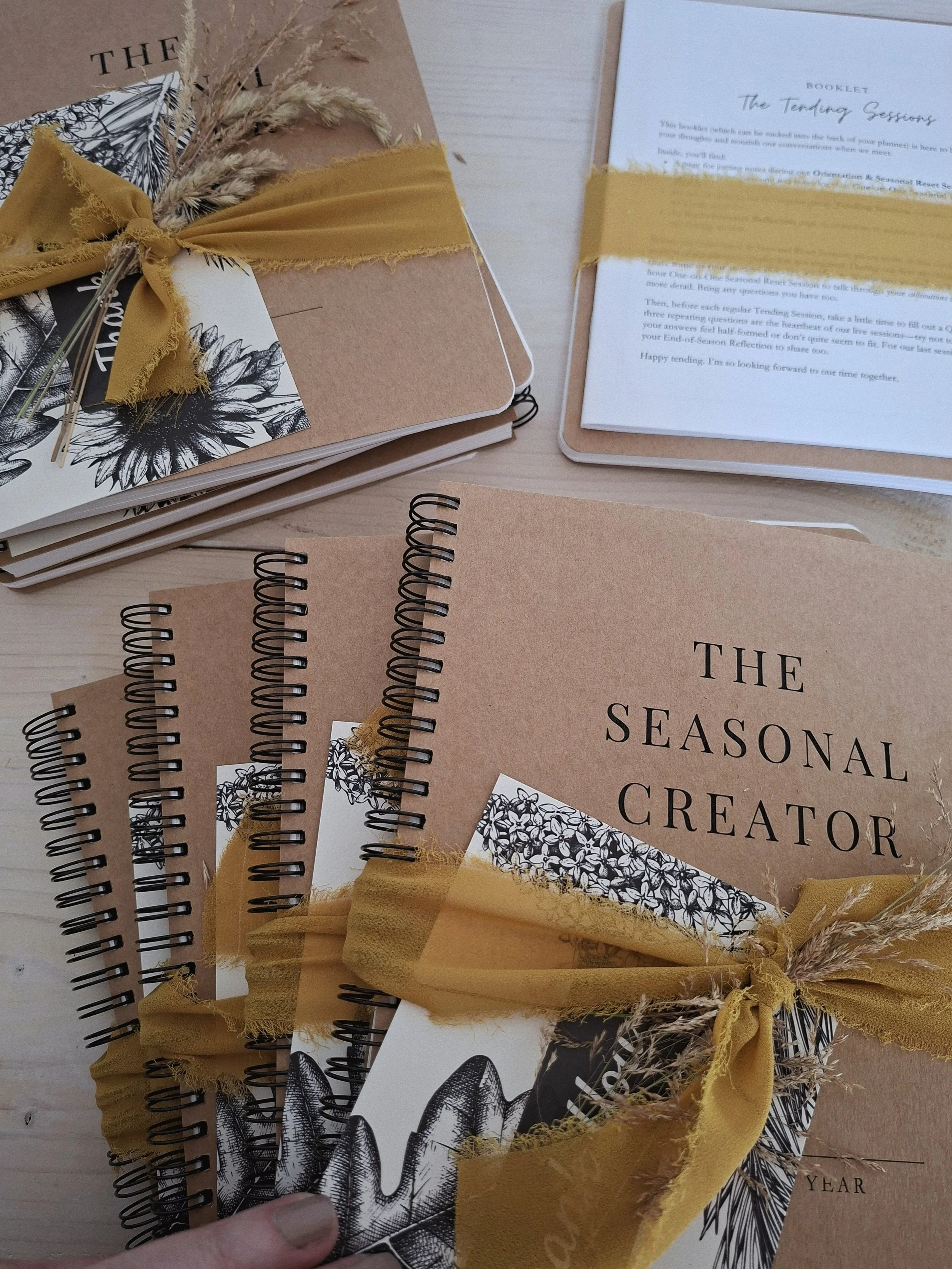 Eight Seasonal Creator Workbook & Planners packaged with botanical thank-you cards and ochre ribbon, ready for Group Tending Sessions participants.