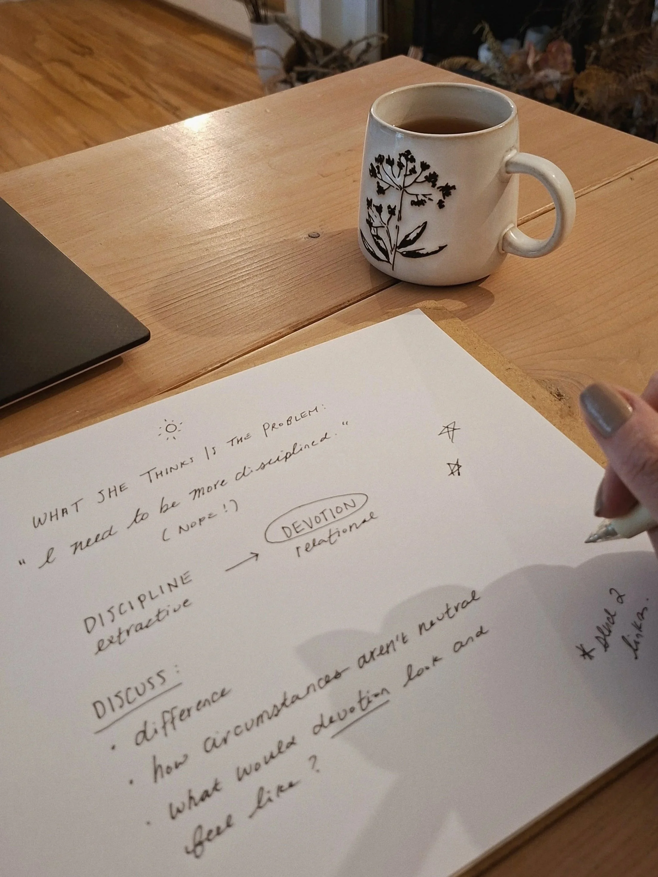 Handwritten notes in progress during a Shine Session, with a botanical mug and laptop on a pale wood table.
