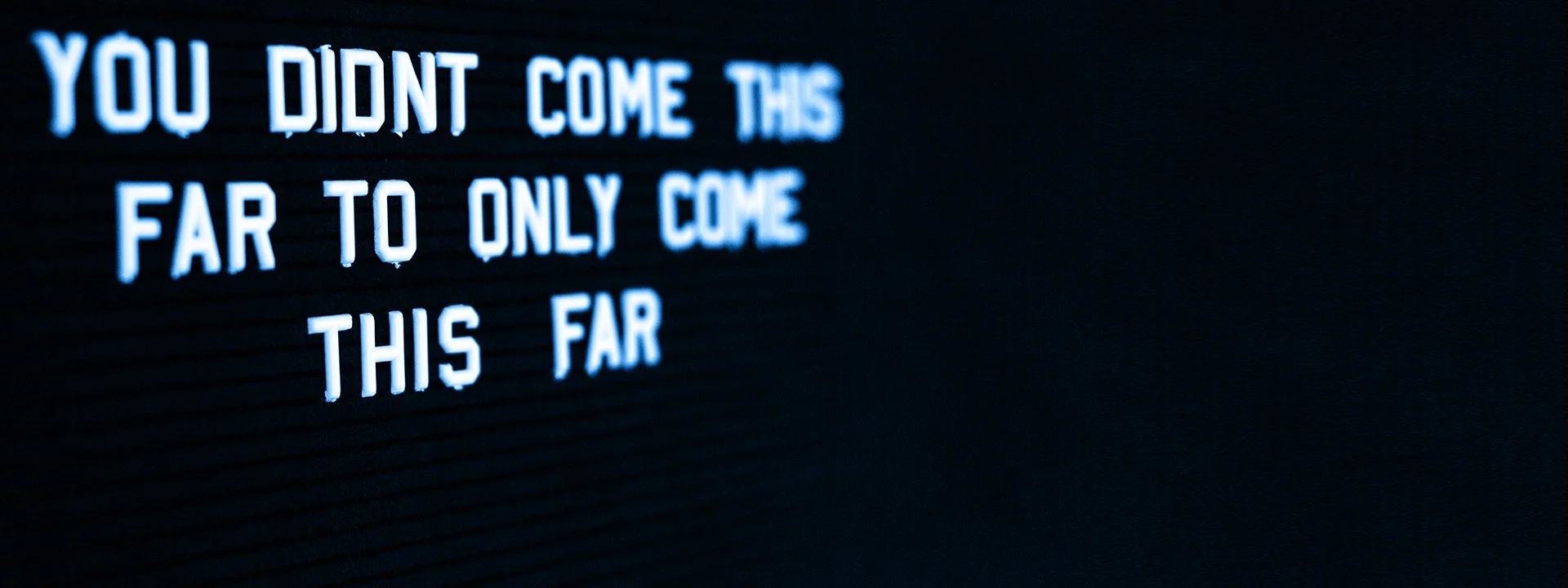 A black letter board with white illuminated text reading, "You didn't come this far to only come this far.".