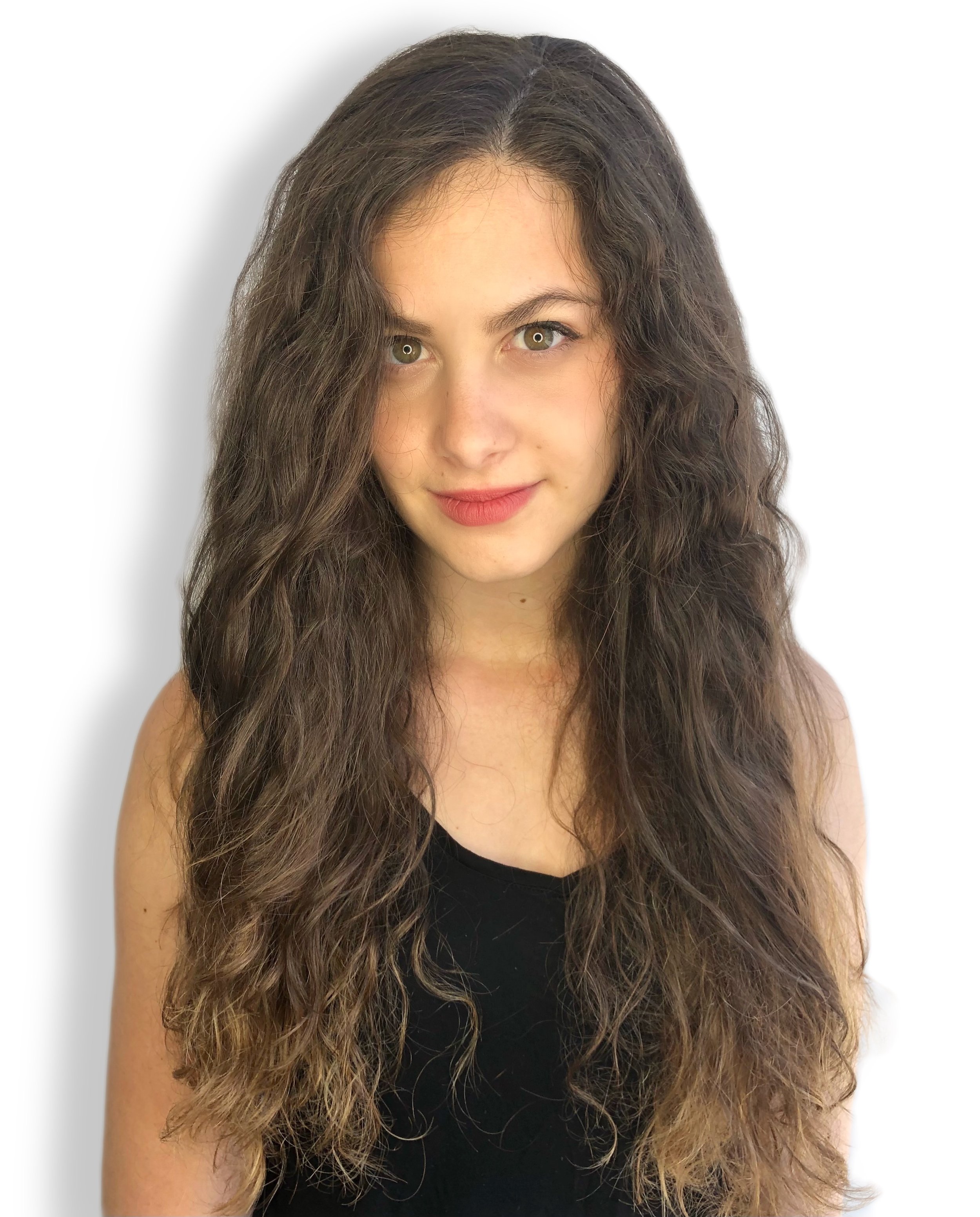 Young woman with long curly brown hair wearing a black top, smiling slightly against a white background.