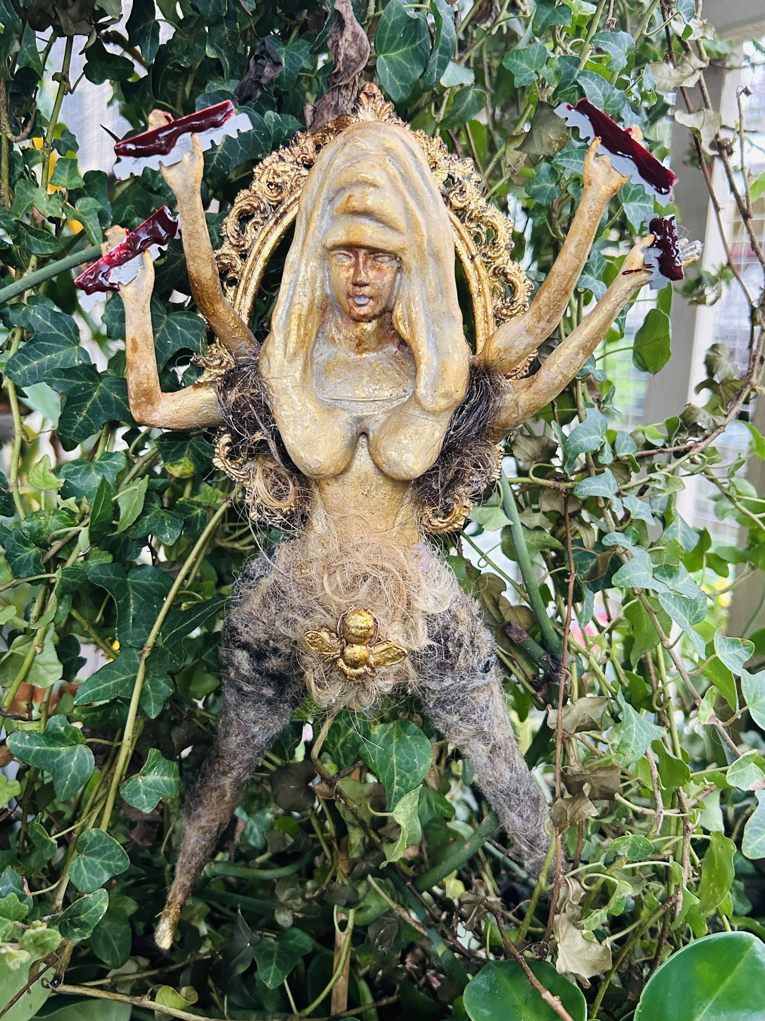 GODDESS HAIRRIET
metal, gold leaf, plaster, bamboo stick, ceramic, paint,
human and doll hair,
54cm x 19 cm. 

The 'Goddess Hairriet' disrupts society's standards by appreciating body hair and its historical significance.
