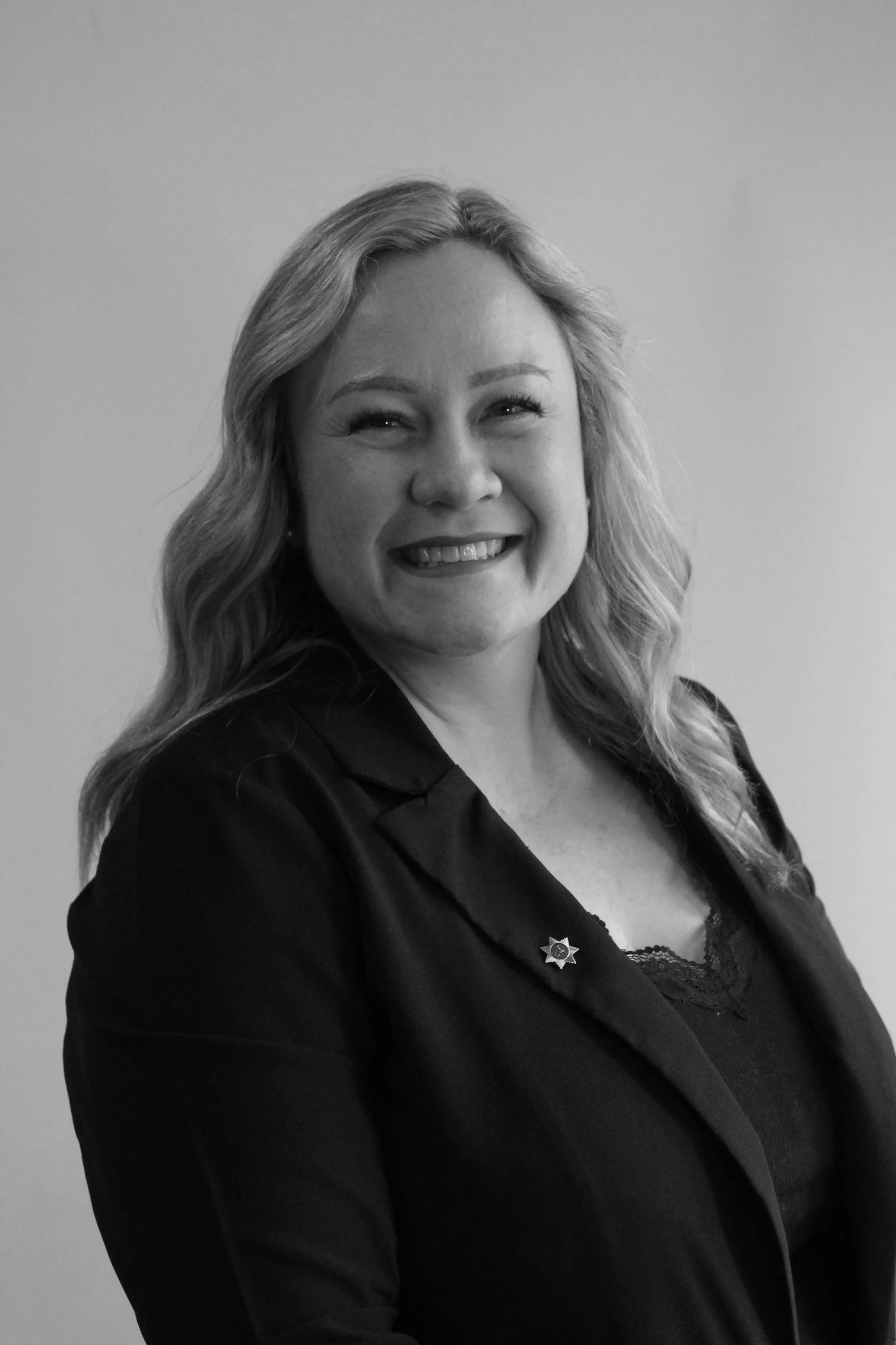 Picture of our chair Bec, Blond chest length hair with a smile on her face