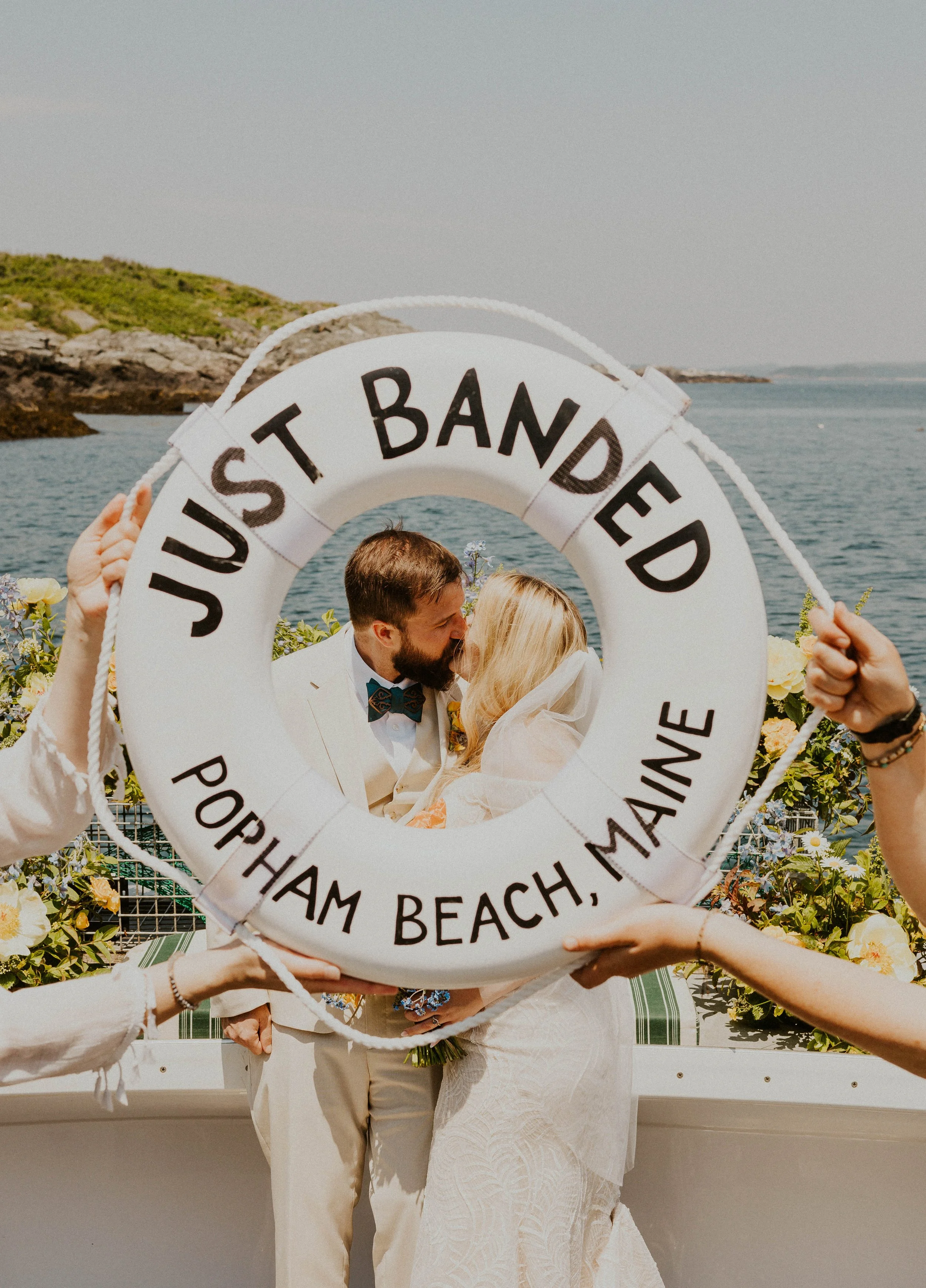 Eloping couple behind Just Banded buoy