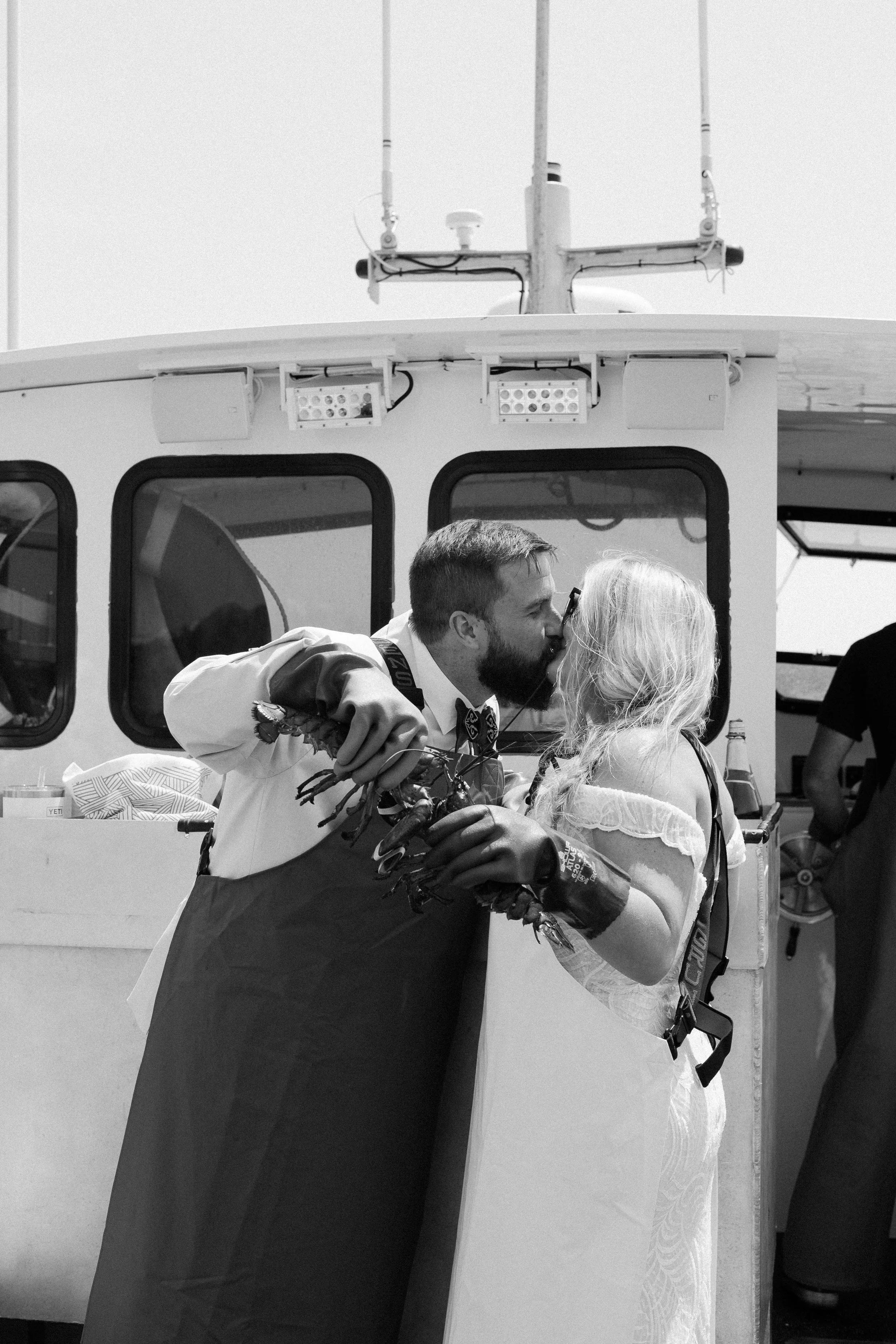 Kissing in their Grundens holding lobsters