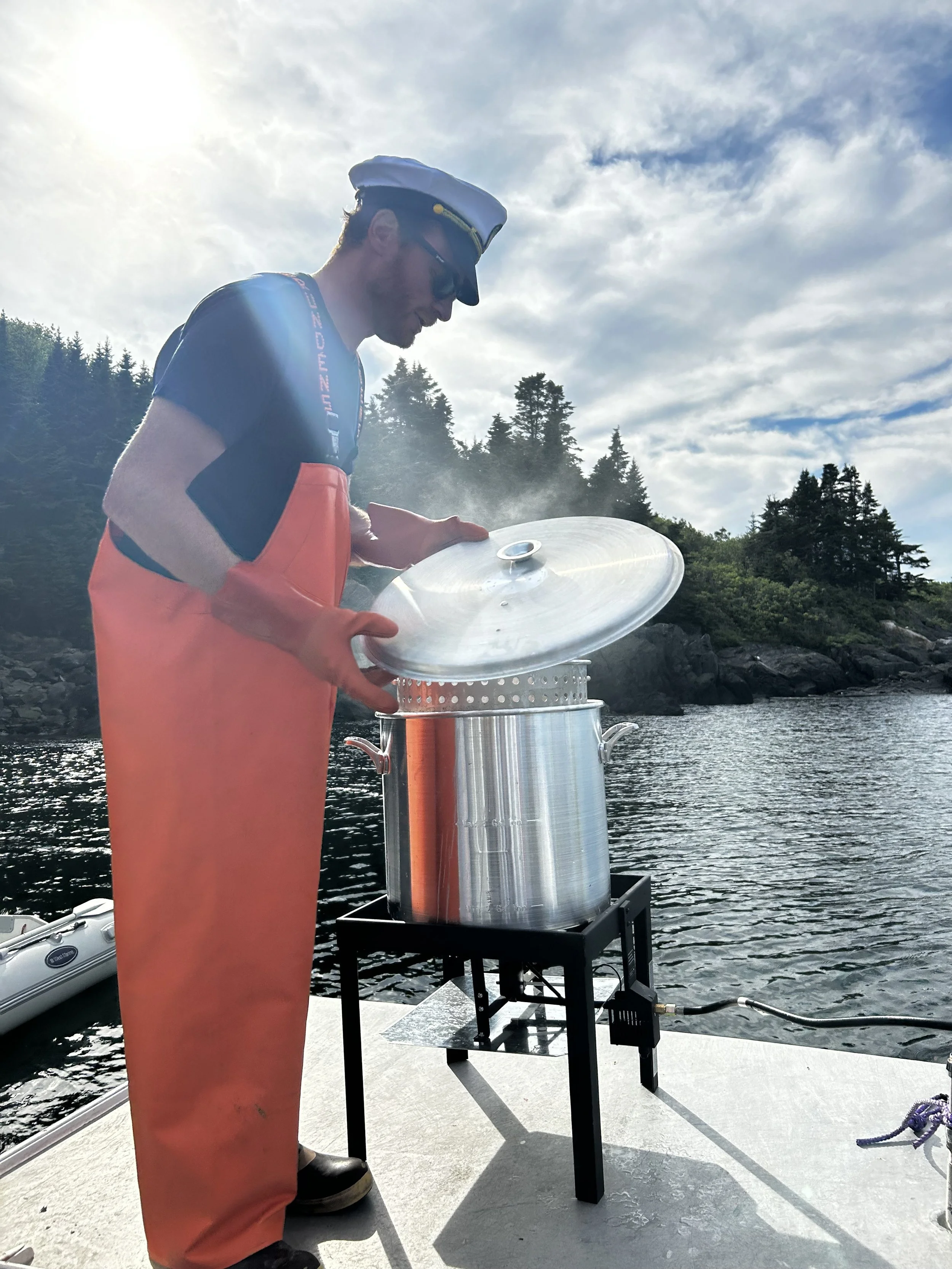 Captain Ethan cooking the lobsters in the cove at Seguin