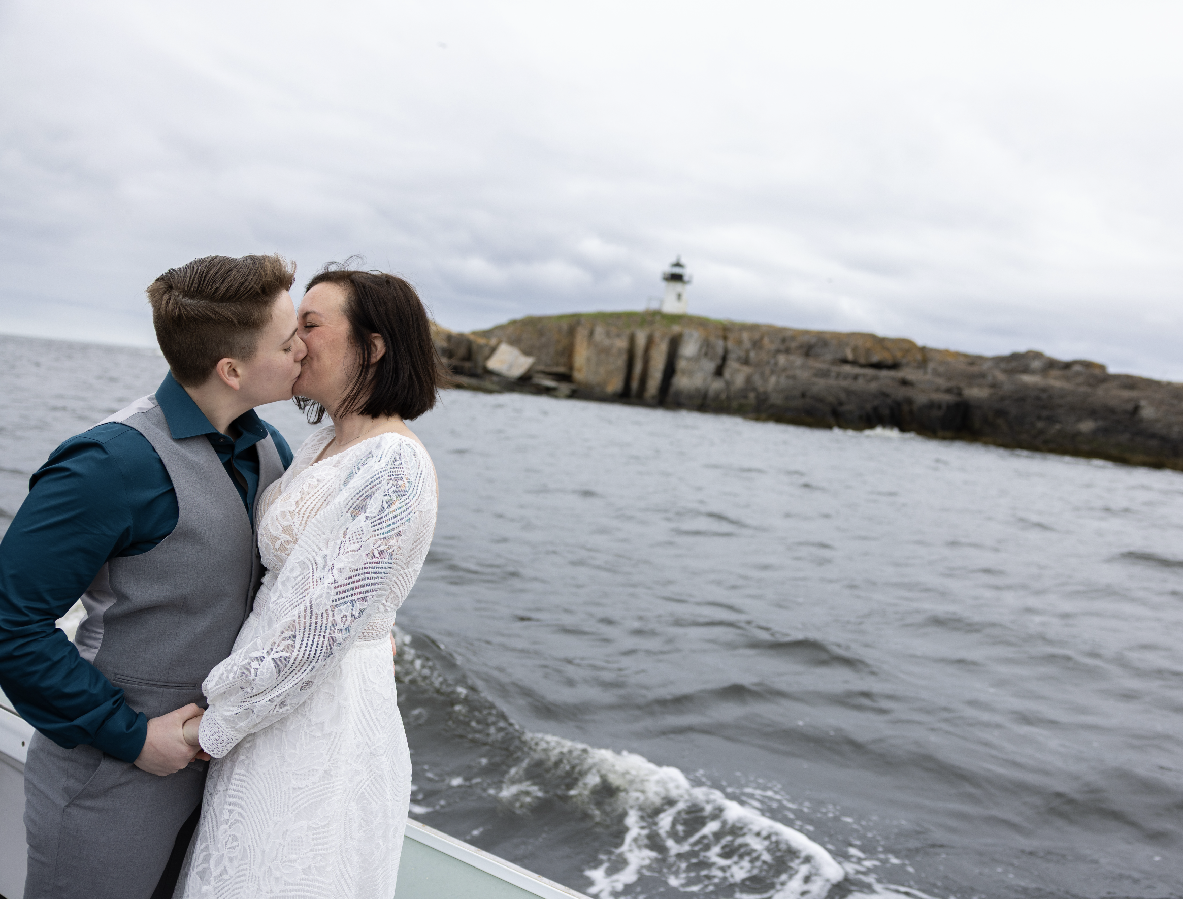 brides kissing on boat while eloping at sea