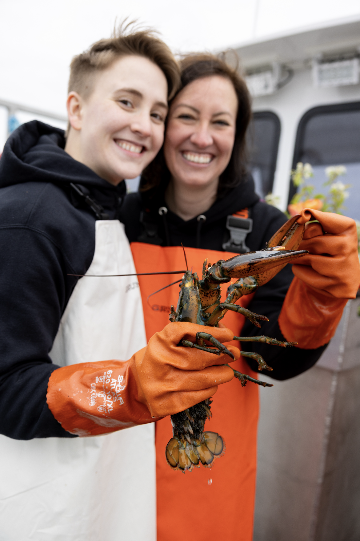 happy brides catching lobster for dinner after elopement
