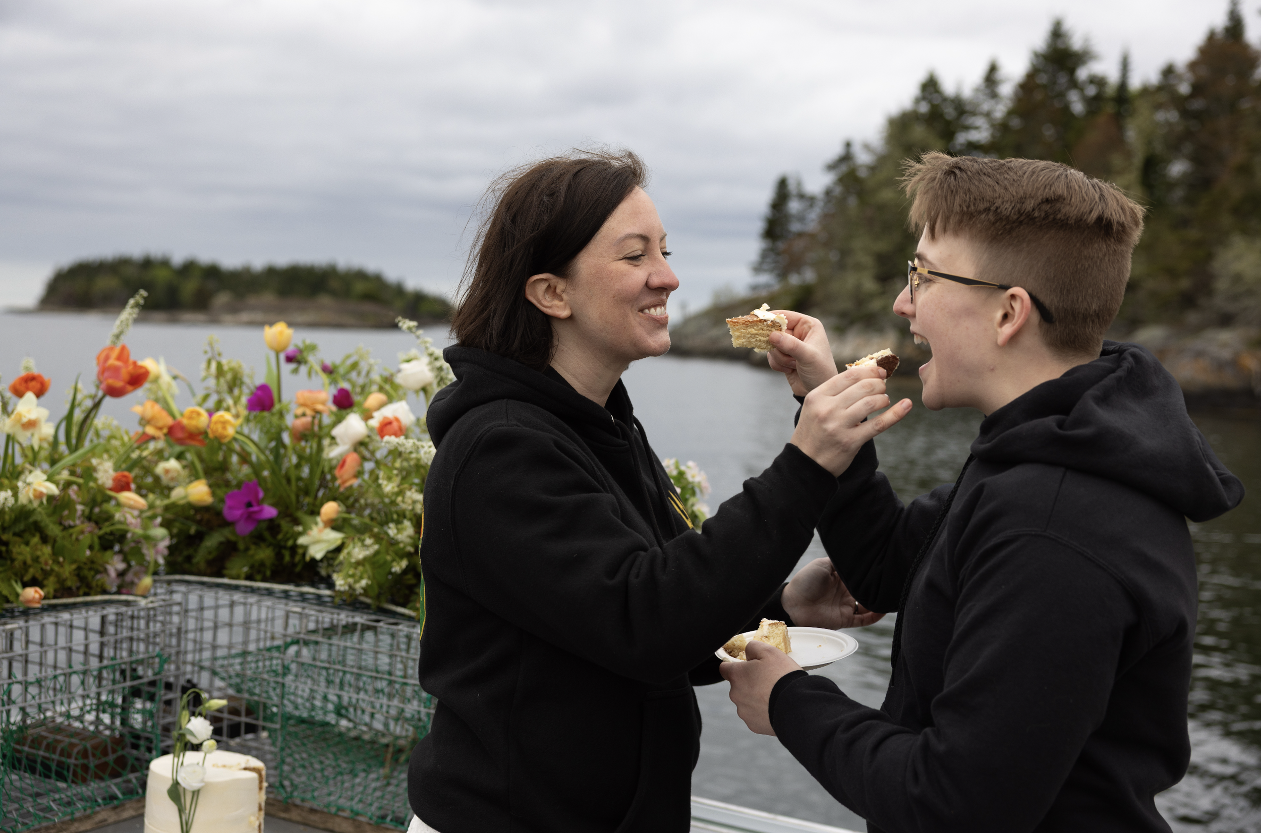 couple eating cake on boat during Maine elopement on the ocean