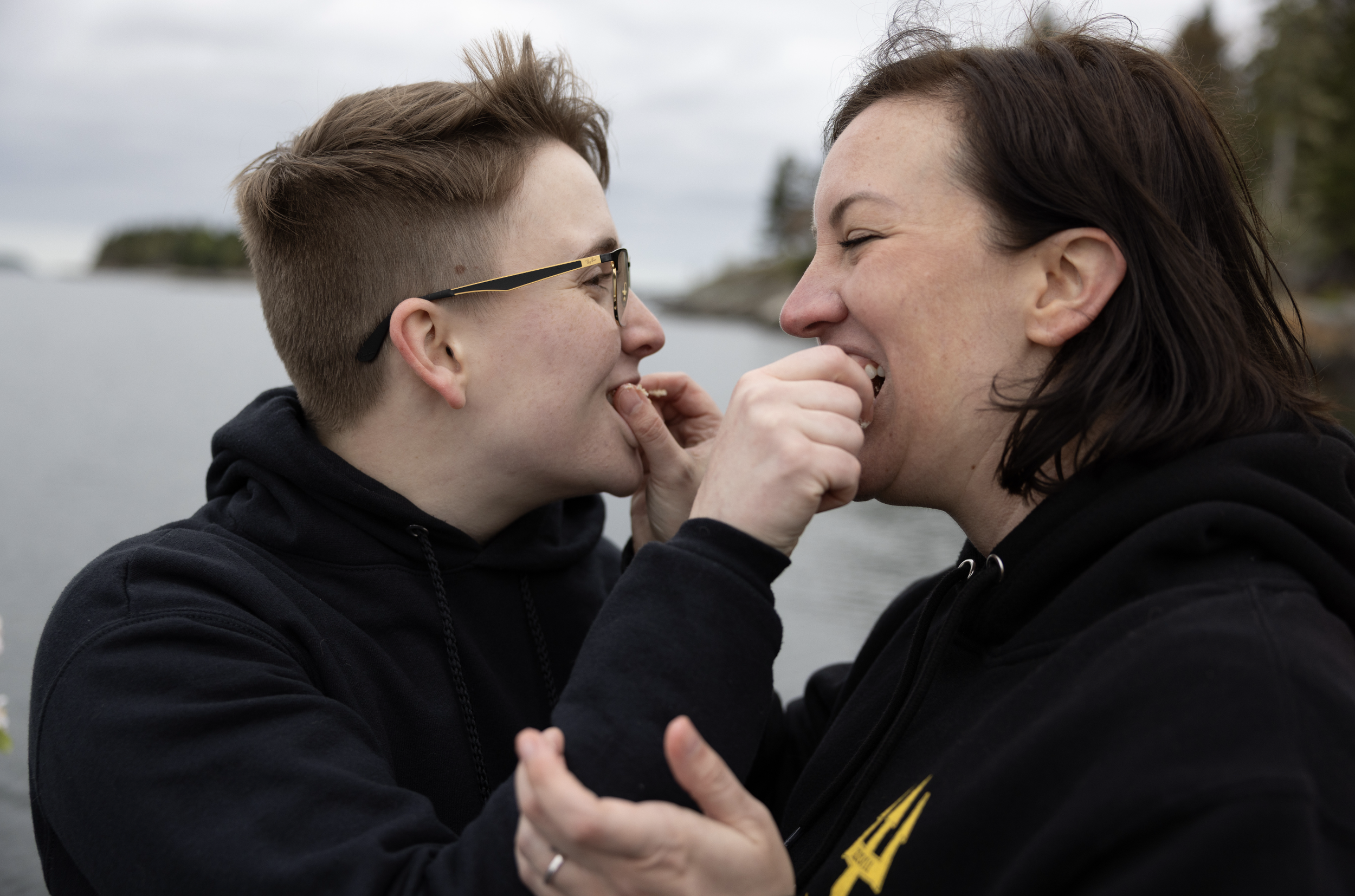 bride and bride sharing cake on boat after Seguin Island elopement