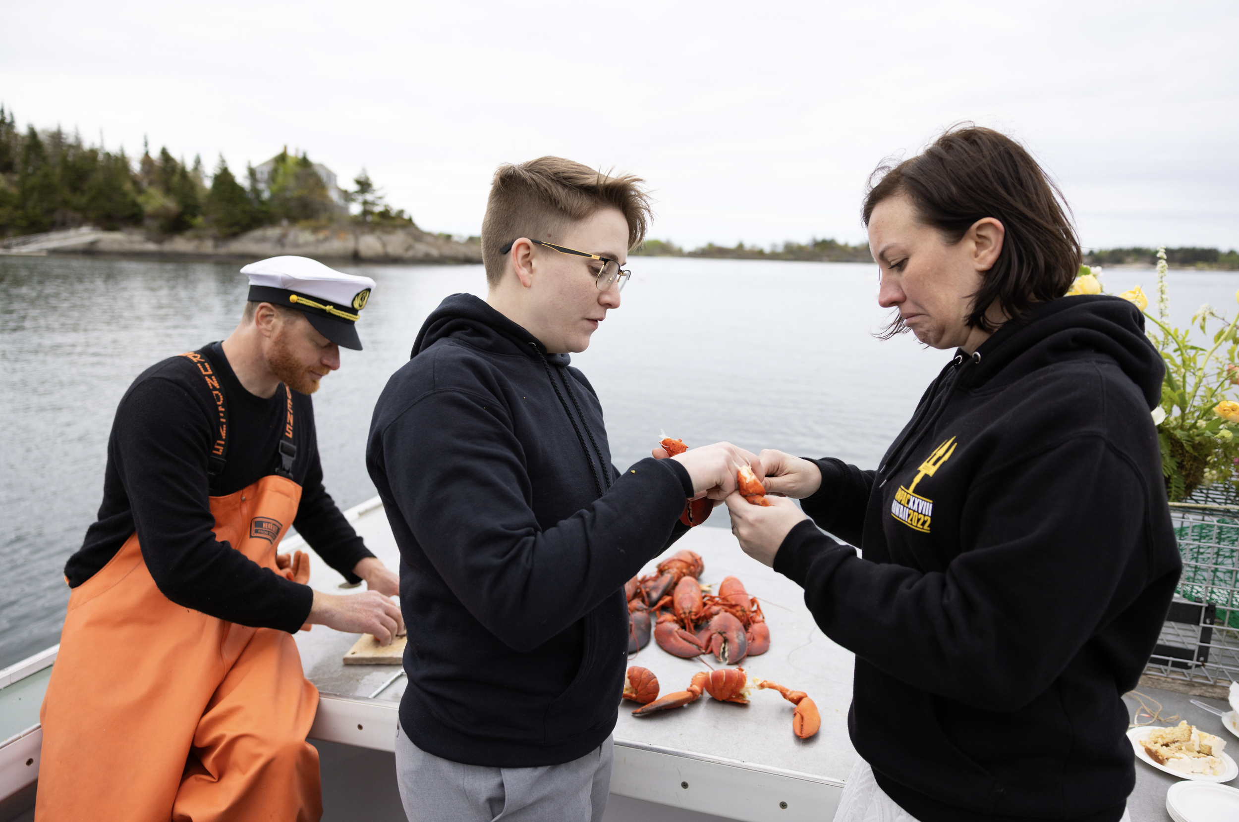 just married couple enjoying lobster bake on boat in midcoast Maine