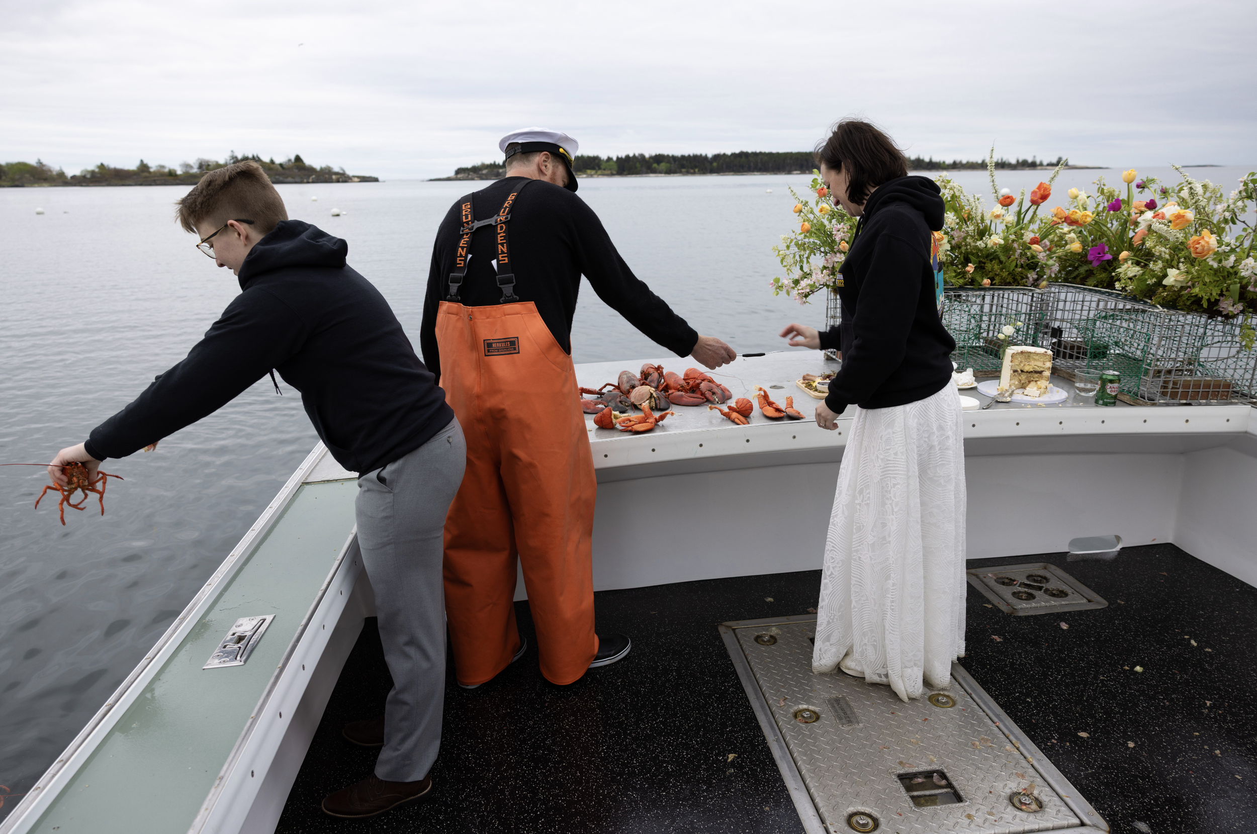 couple celebrating marriage with lobster dinner on boat in Maine