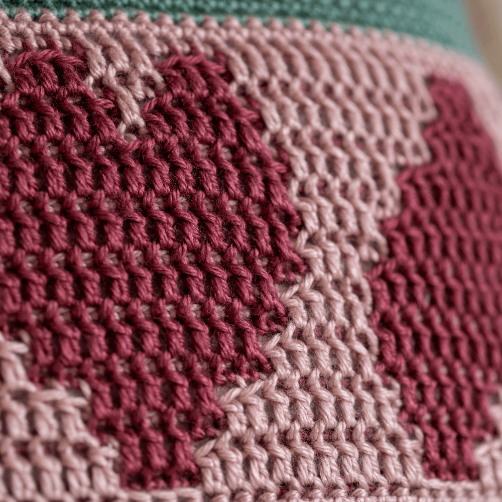 close up of a heart on the crocheted simply love mosaic cushion cover in green and pink tiny.png