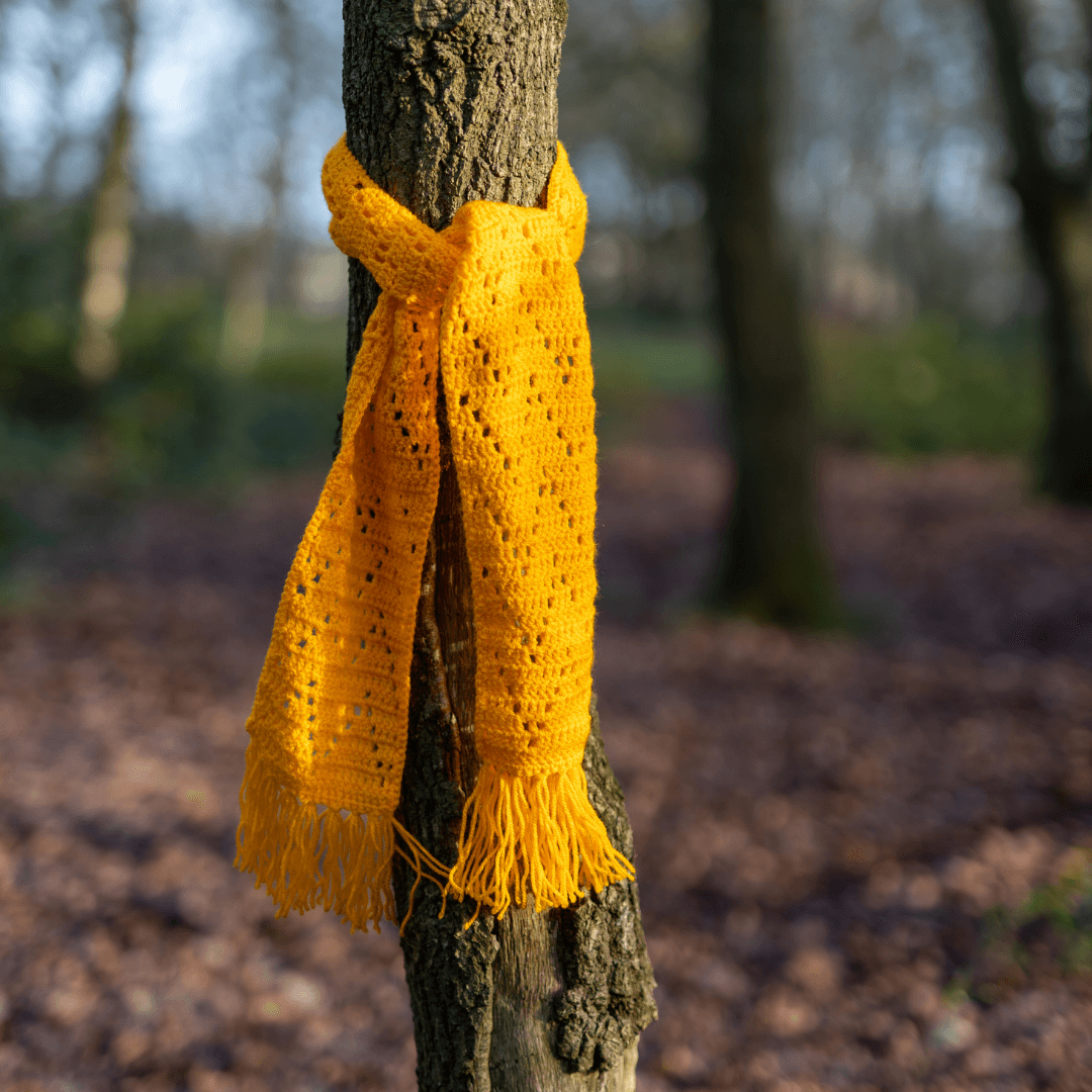 yellow caitlin zigzag scarf wrapped around a tree.png