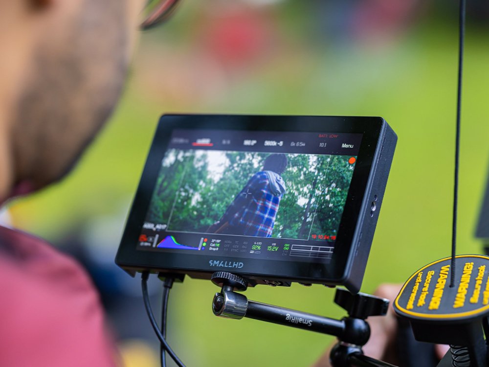 Behind the scenes photo of a monitor attached to a camera during filming for a commercial