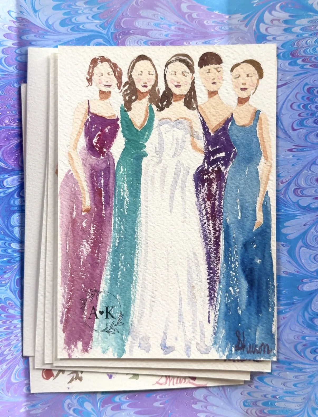Watercolor painting of five women dressed in colorful evening gowns standing side by side, on textured paper with a swirled blue and purple background.