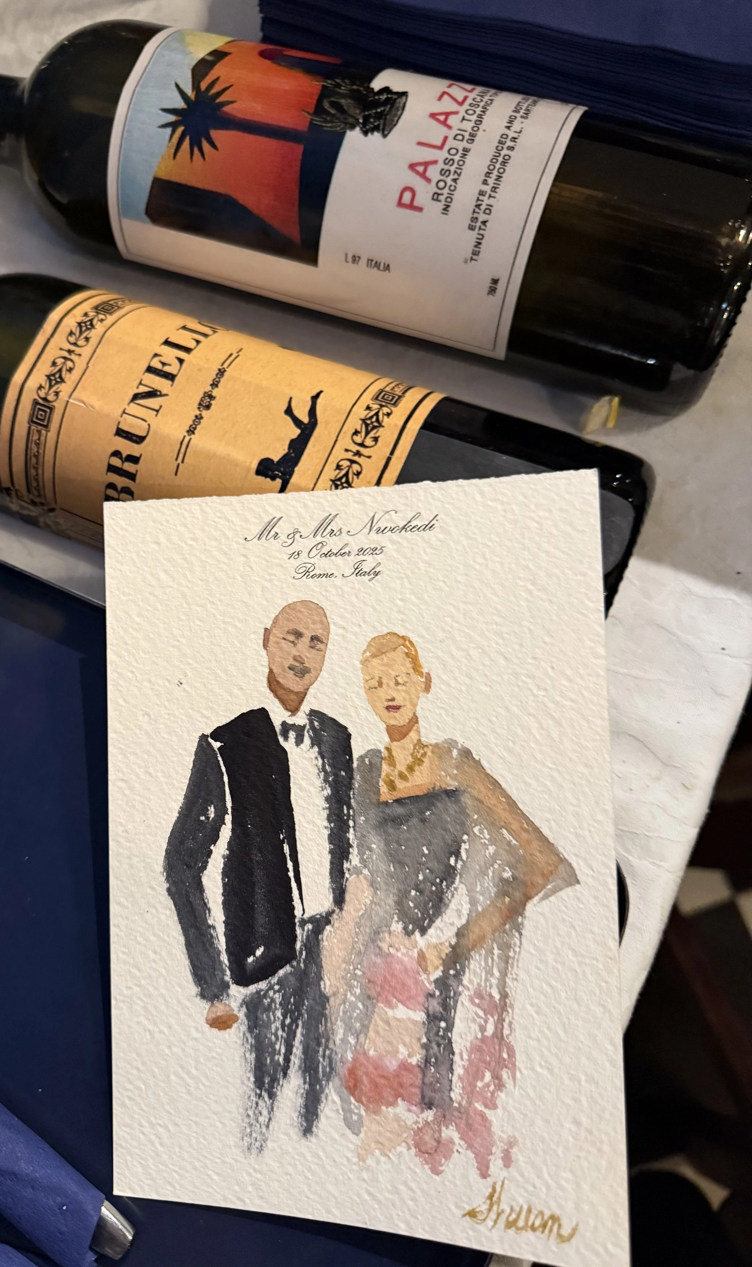 An italy live wedding portrait watercolor painting of a couple dressed in formal attire, the man in a black tuxedo and the woman in a black gown with pink and gray accents, with handwritten addresses at the top and the name 'Alicia' at the bottom.