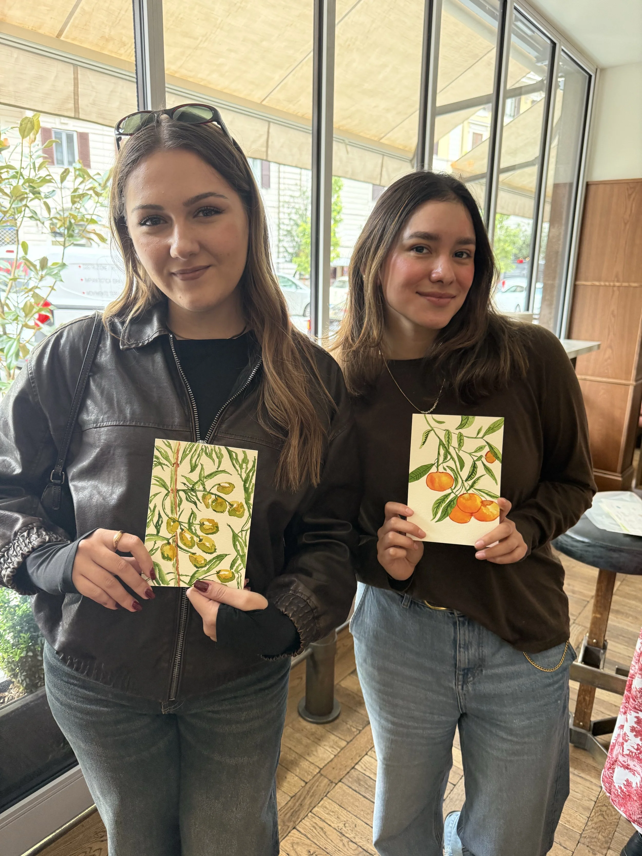 Studio Sheean art students painting botanical flowers while enjoying traditional Italian appetizers and wine in a historic setting.