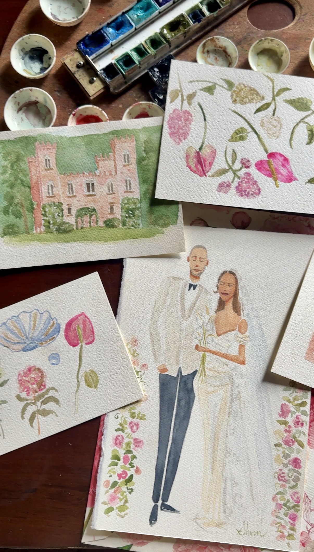 Italy wedding illustrations of a castle in Veneto, a wedding couple, and various floral and fruit designs on textured paper, surrounded by watercolor paint palettes and brushes.
