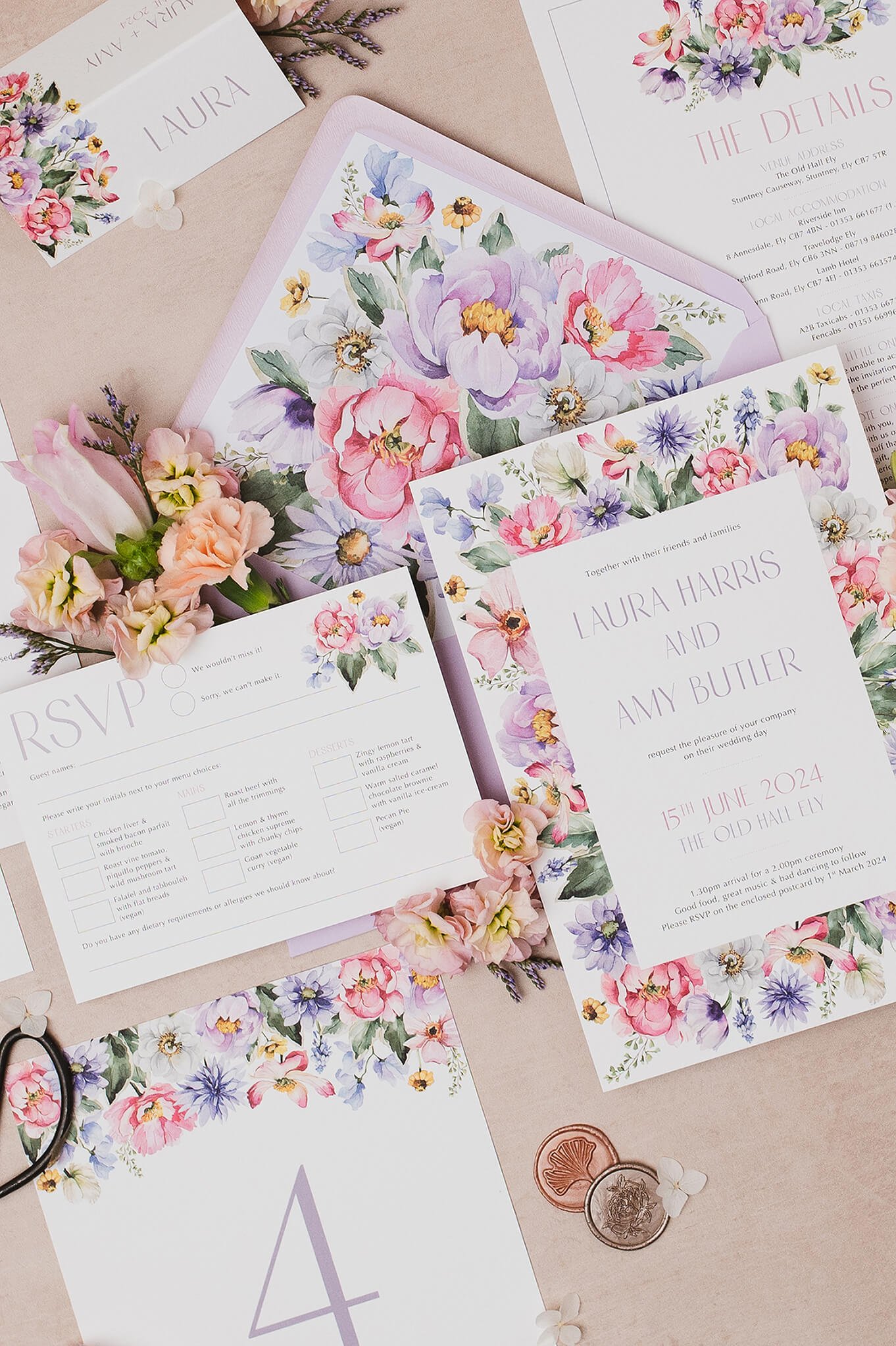Wedding invitation suite with floral watercolor designs, including a 'Save the Date' card, wedding details card, and RSVP card, arranged on a light wooden surface.