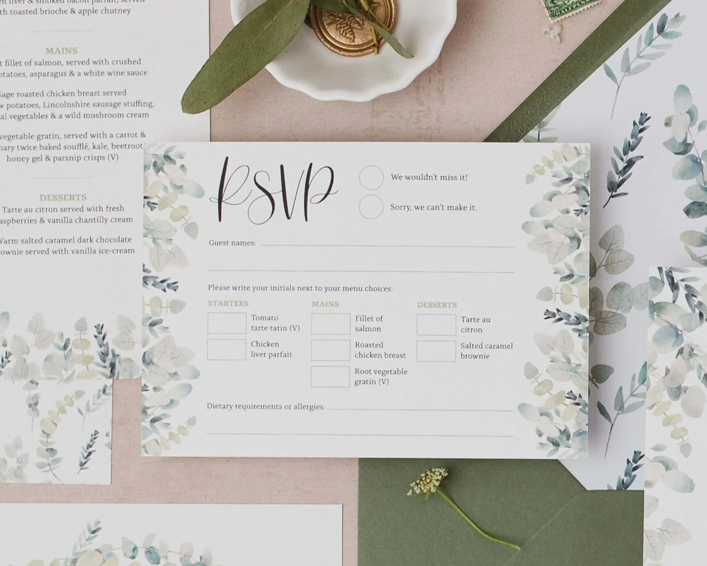 A sage green eucalyptus print wedding RSVPs with menu options and matching wedding invitations.