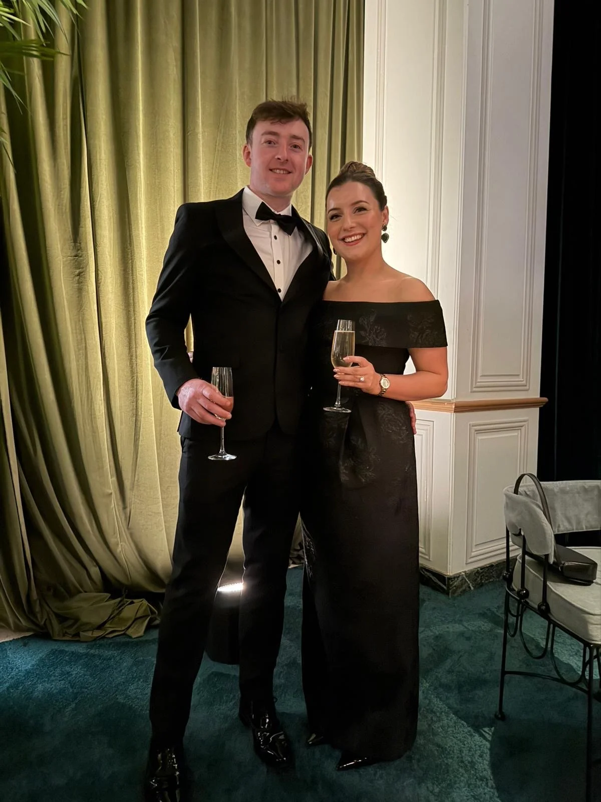 Roisin and Michael standing together holding champagne