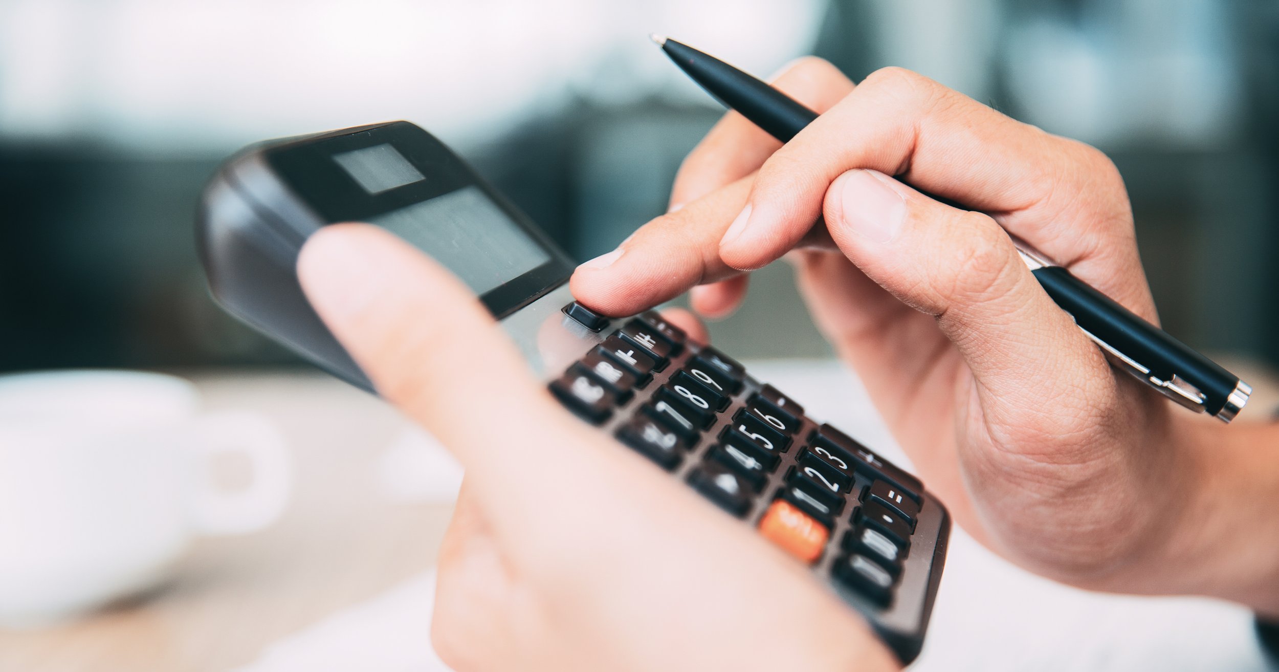 person typing numbers on calculator