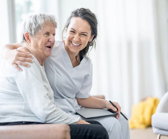 caregiver sharing a photo album with an elderly woman at home