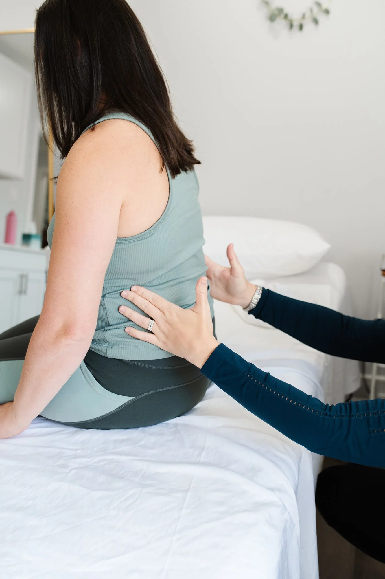 A pelvic floor physical therapist doing an assessment on a patient's breathing in pelvic health PT