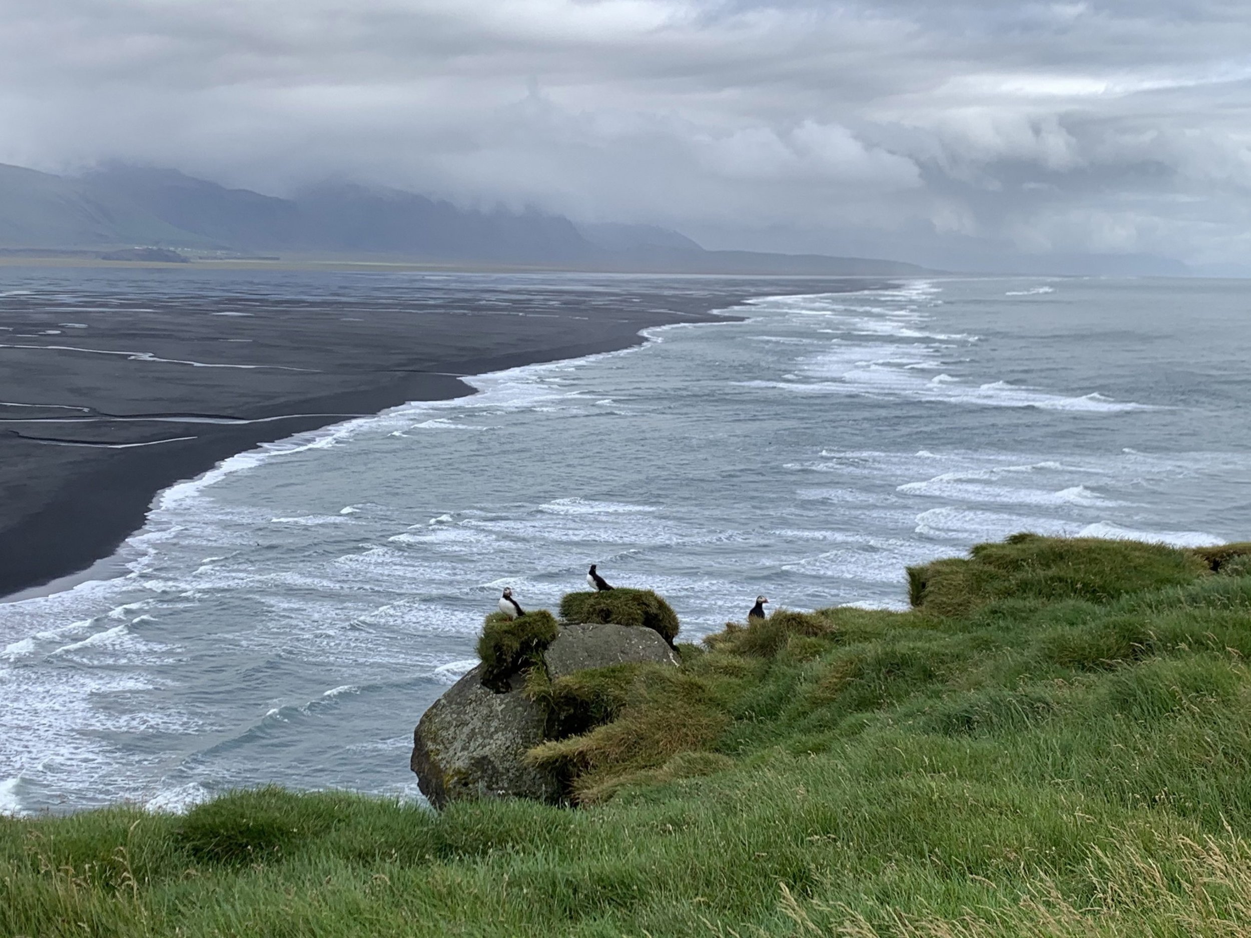 sharp-cliffs-against-a-flat-black-sand-beach-scaled.jpg