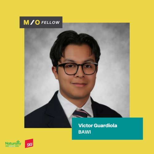 Professional headshot of Victor Guardiola, a M/O Fellow and BAWI, wearing glasses and a dark suit with a white shirt and striped tie, against a gray background with a yellow border and text overlays.