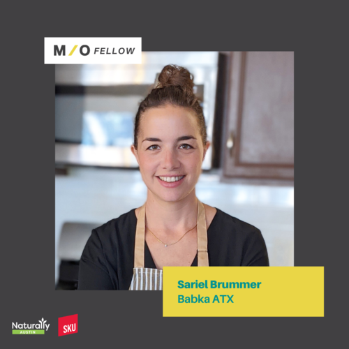 Portrait of Sariel Brummer smiling, wearing an apron in a kitchen, with a yellow name tag that says 'Sariel Brummer Babka ATX.'