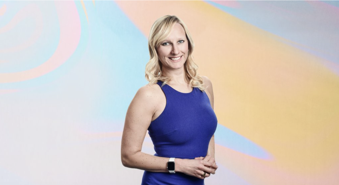 Allison Hohn smiling in front of a pastel background