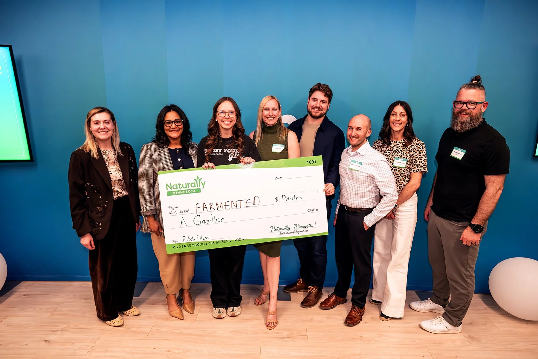 Farmented team holding a giant check