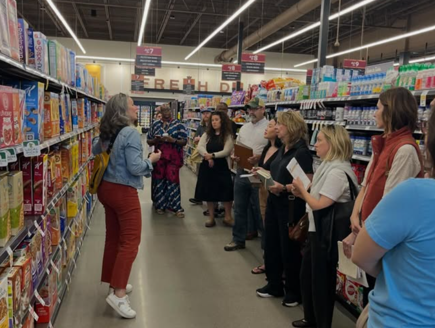 Group of Retail Launch Lab participants in a retail store listening and taking notes.