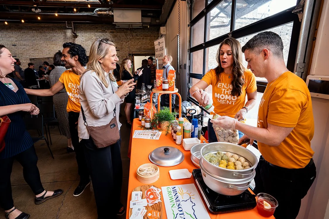 People talking to one another while one person is serving their product that is a food