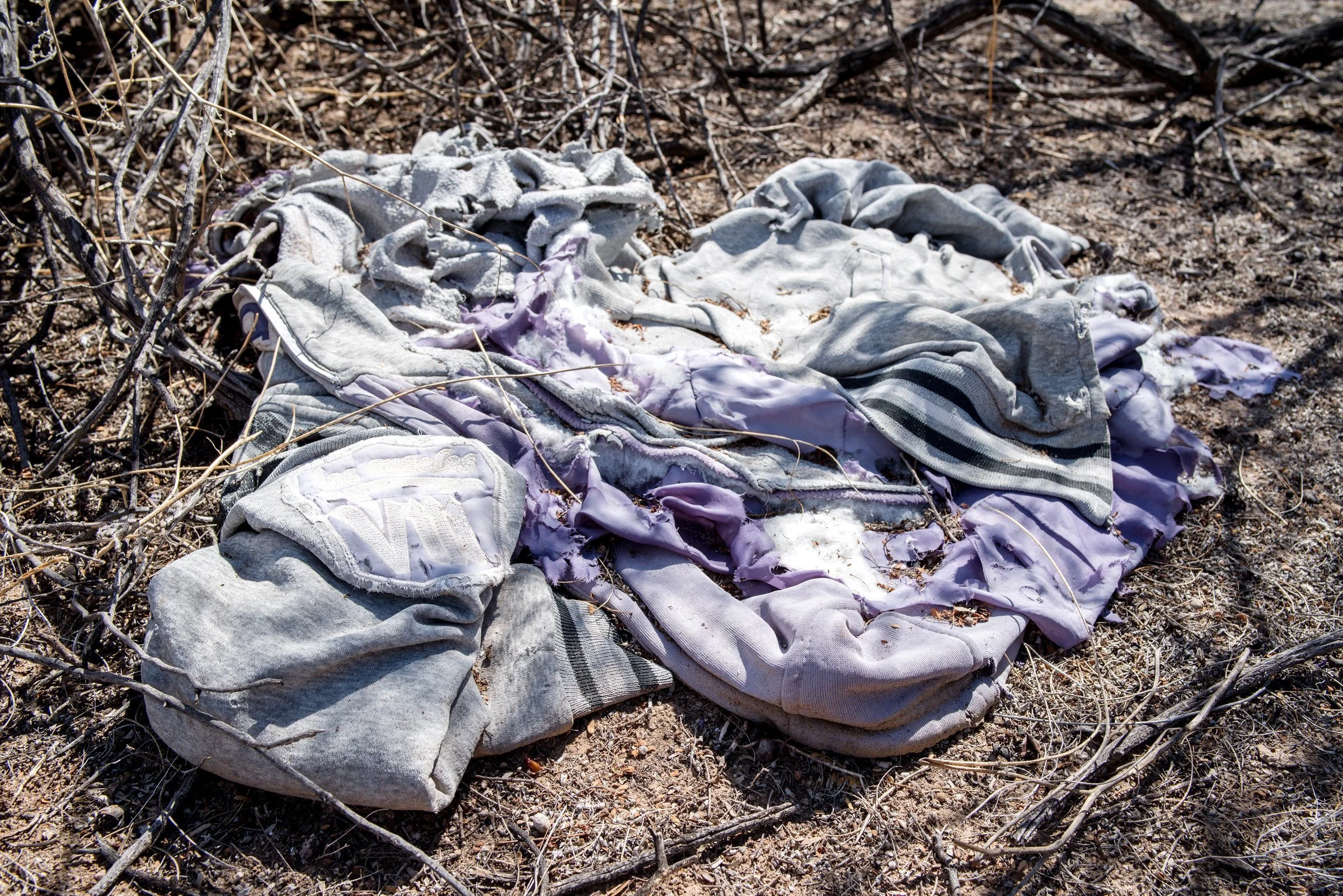  Pieces of clothing, often with the logos of U.S. sports teams, are strewn along the trails throughout the desert. 